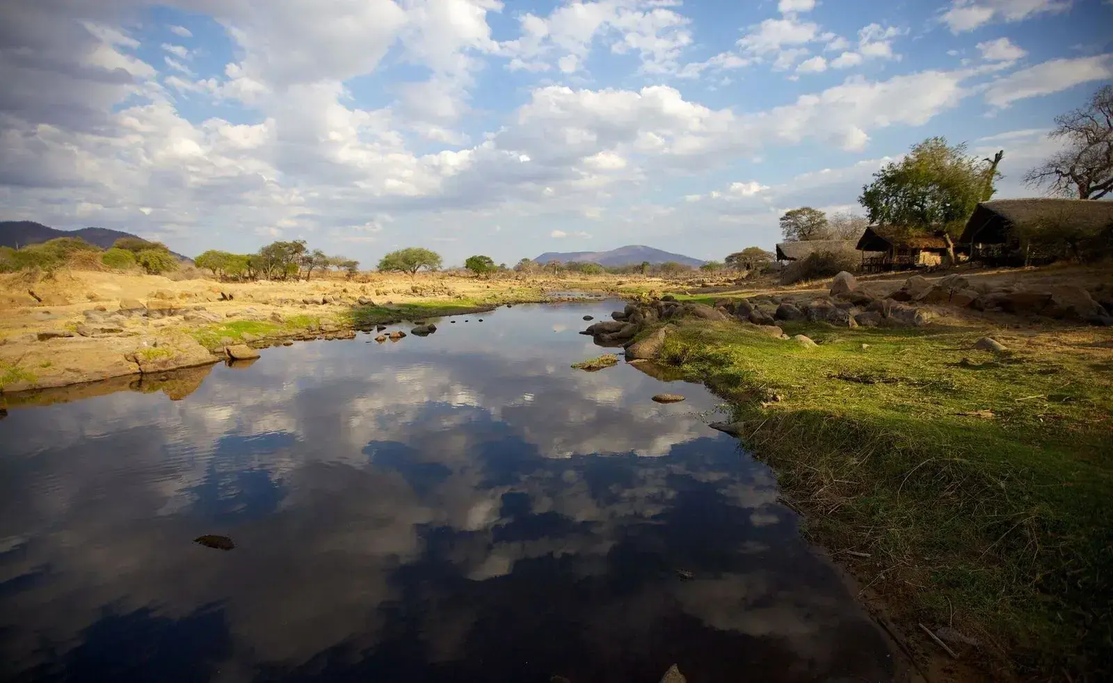 The Great Ruaha lies still beneath the hills, the dry-season bush drawn down to the water.