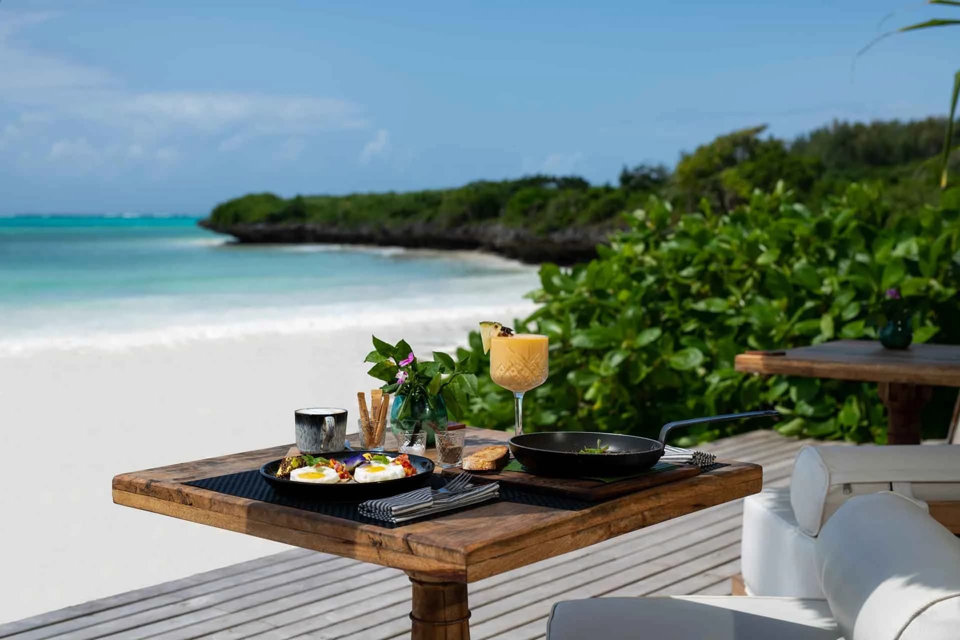 Breakfast table overlooking a pale sandy beach and turquoise water