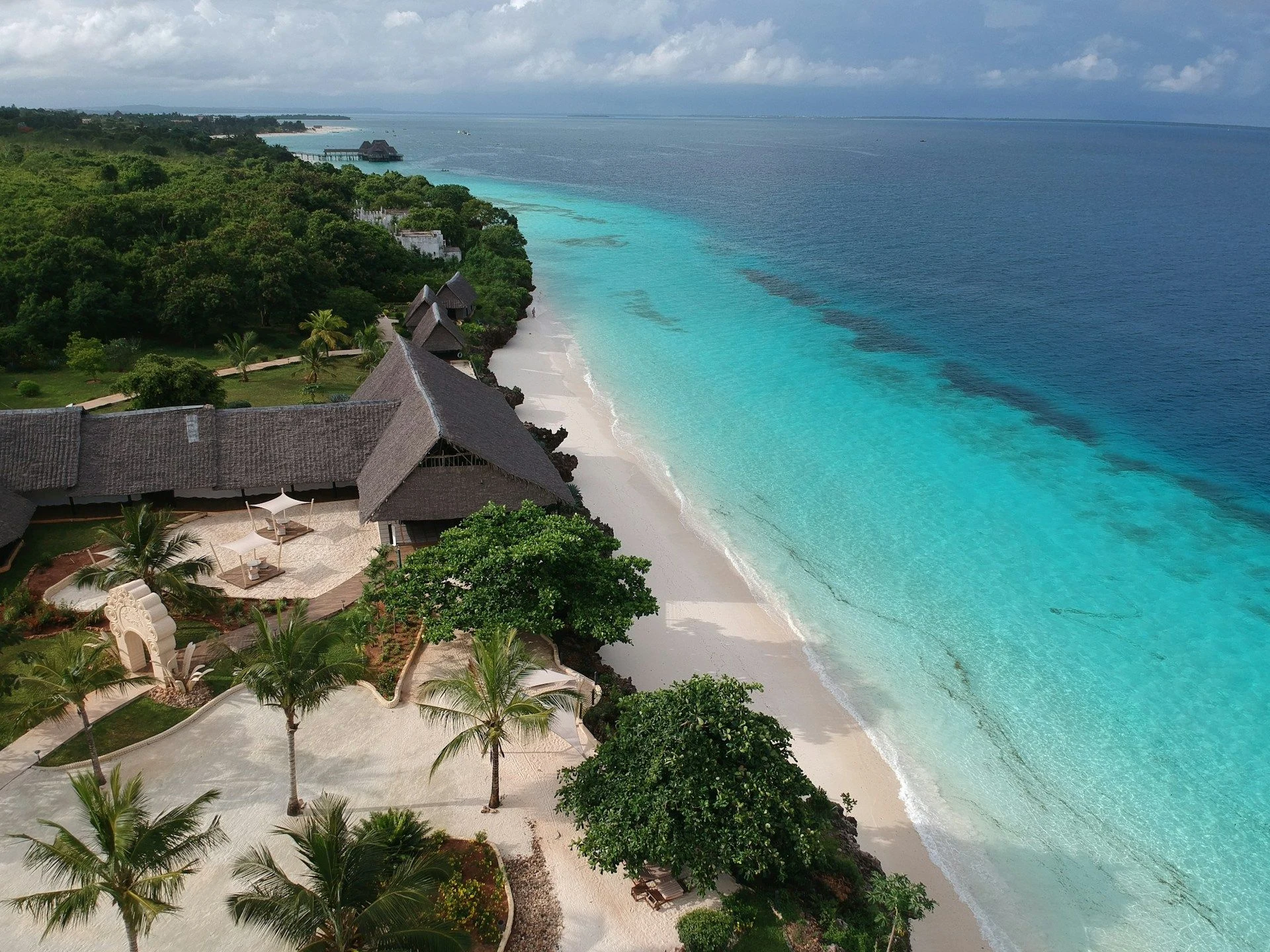 Beachfront cottages above a white sandy beach and turquoise sea