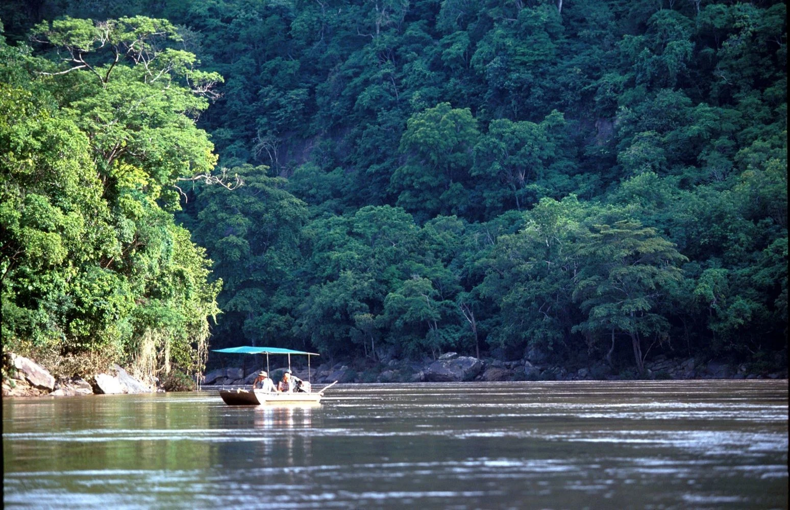 Boat crossing a forest lined river at Sand Rivers Selous