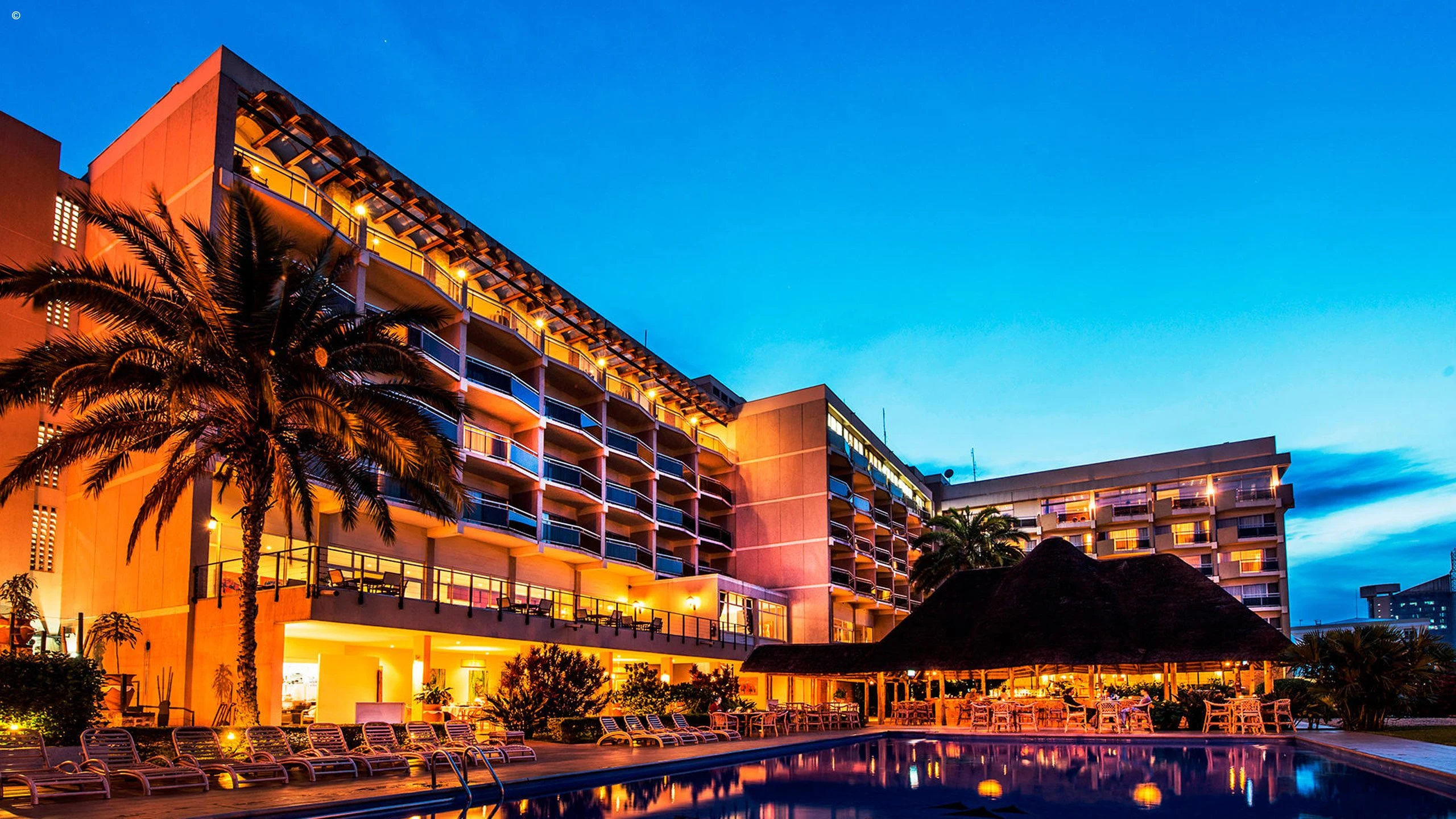 Large hotel illuminated at dusk at Hôtel des Mille Collines