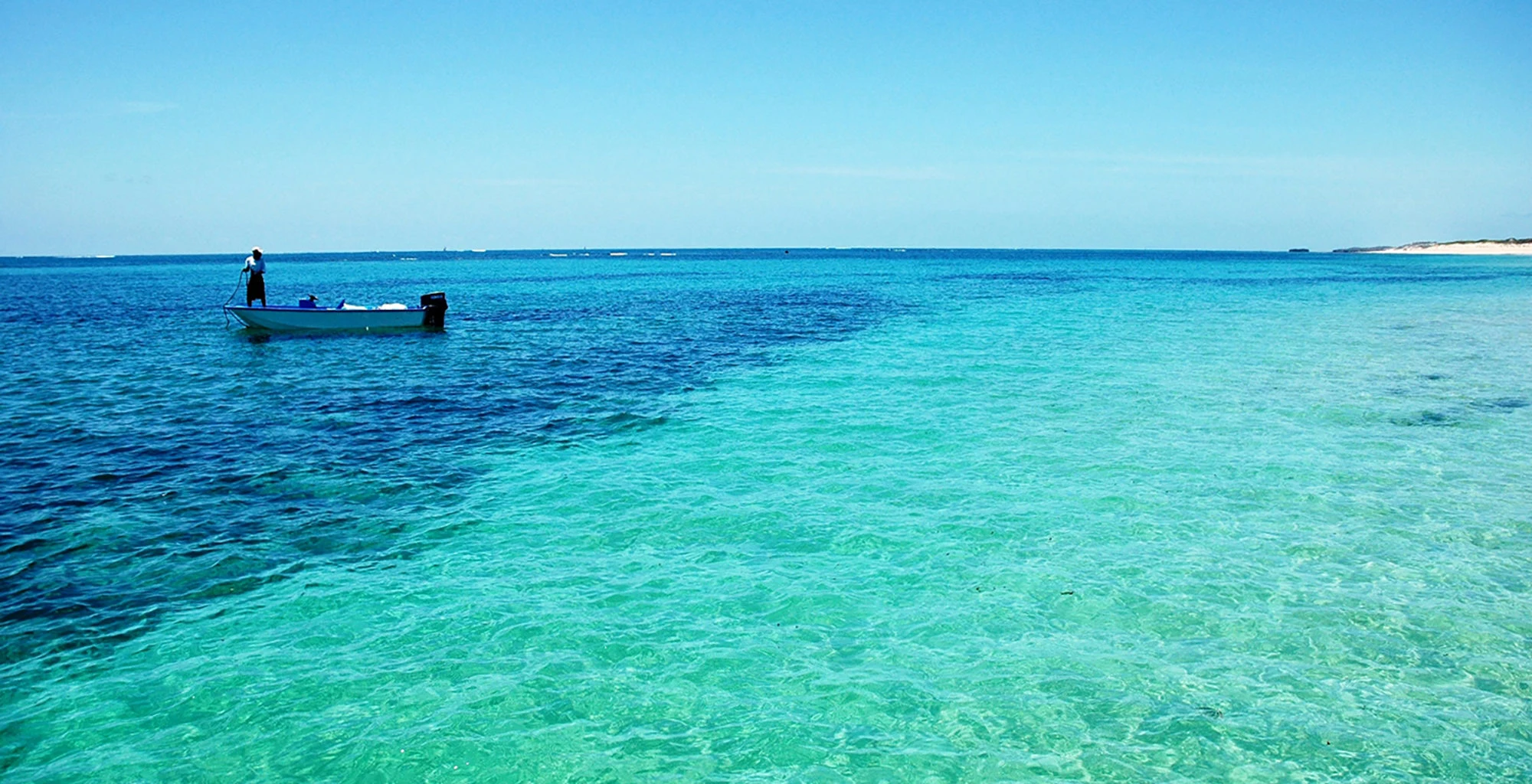 Small boat on clear turquoise water off the Kenyan coast