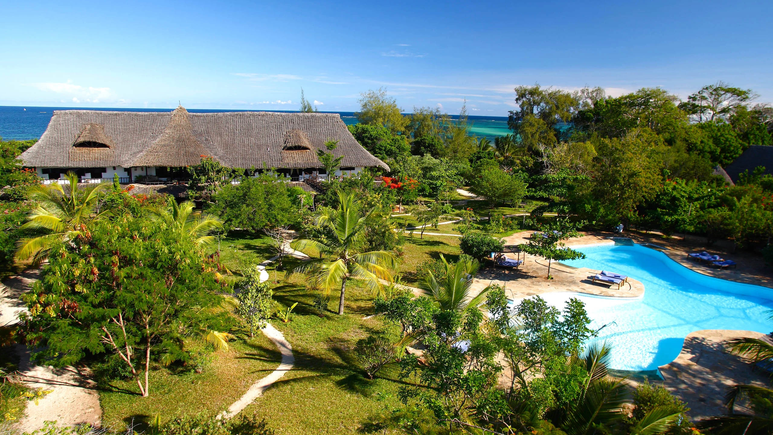 Thatched main house, gardens and pool above the sea at Kinondo Kwetu