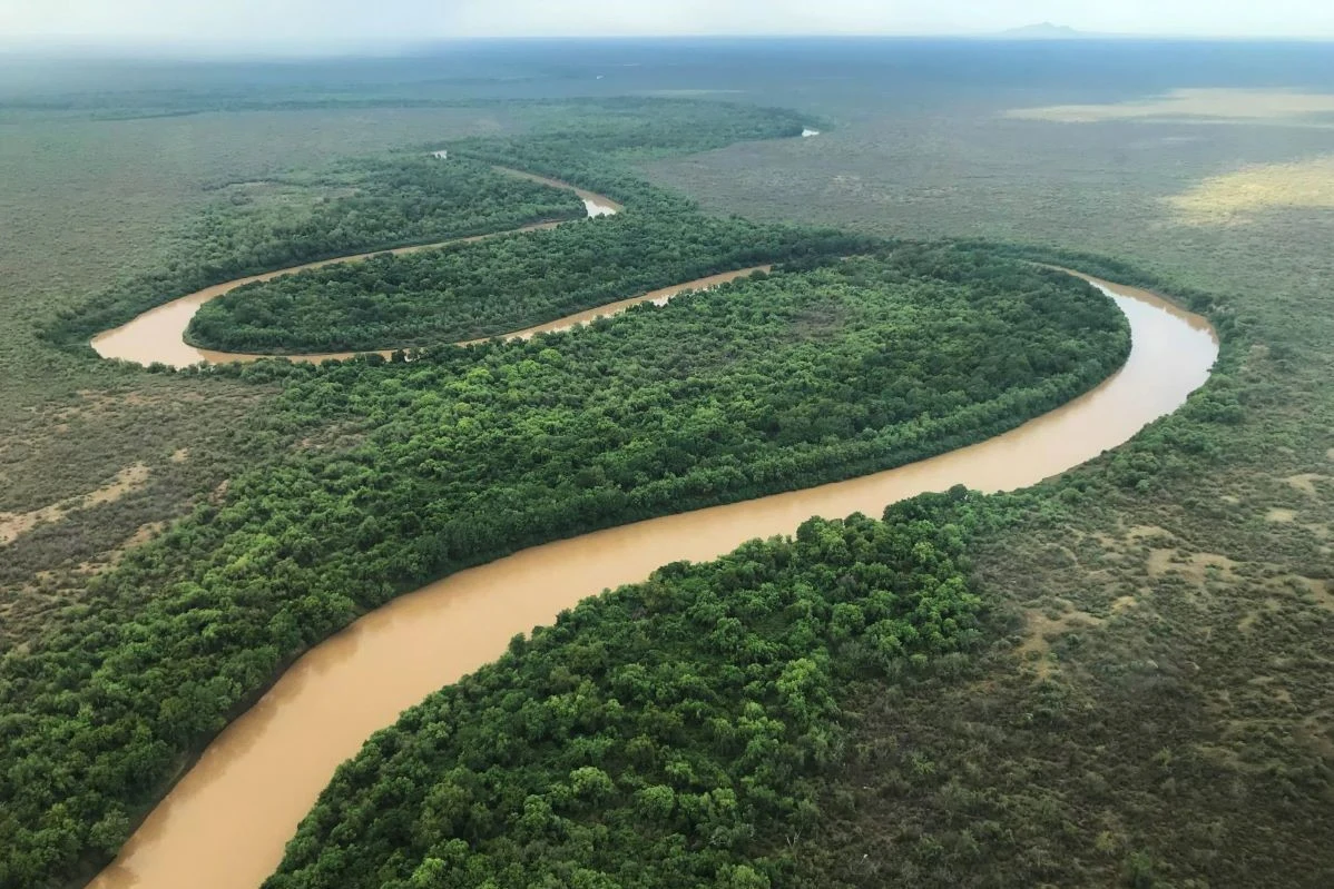 The Omo River winds in wide loops through green forest, seen from the air.