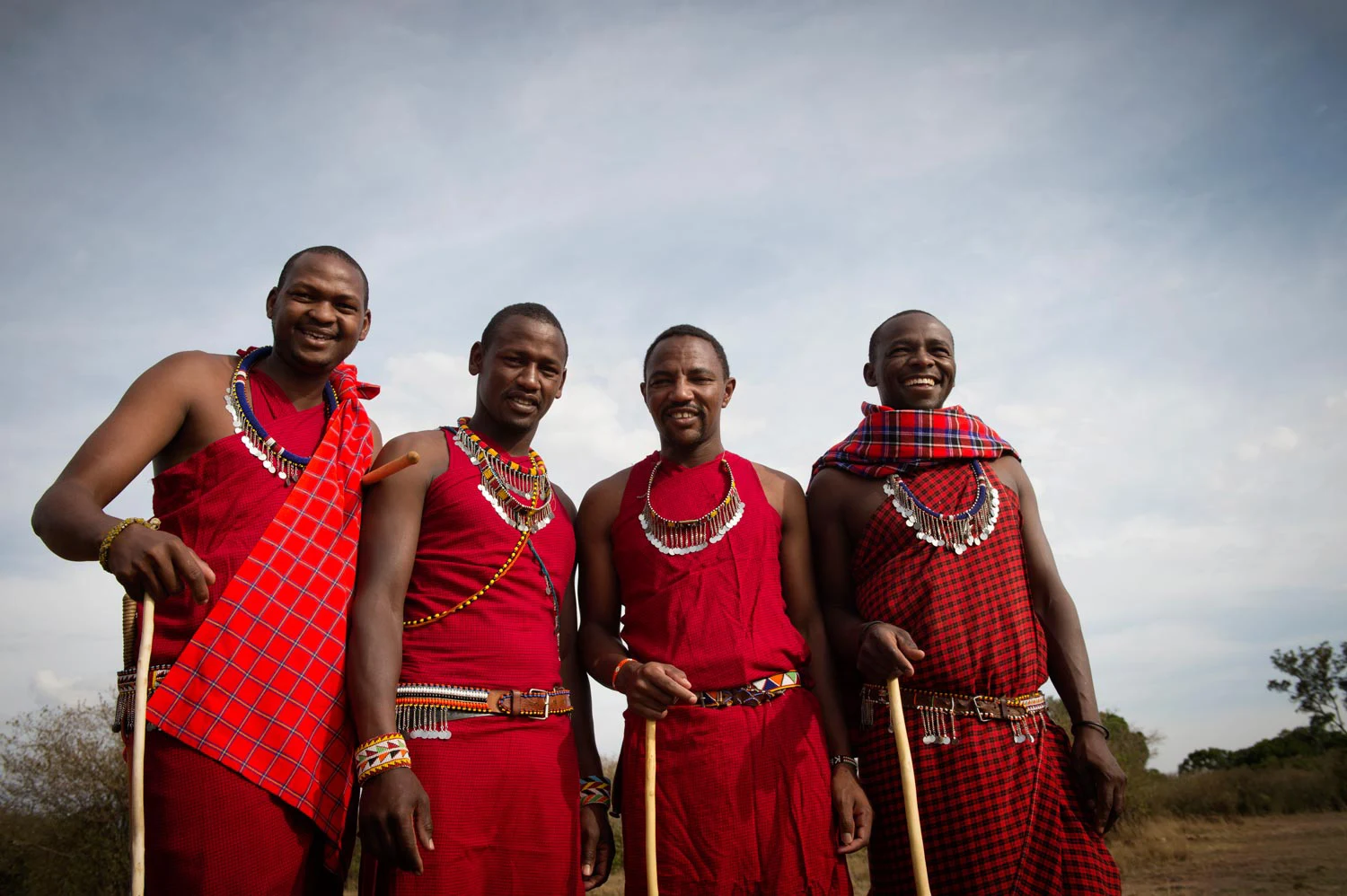 Four Maasai men in red cloth standing together