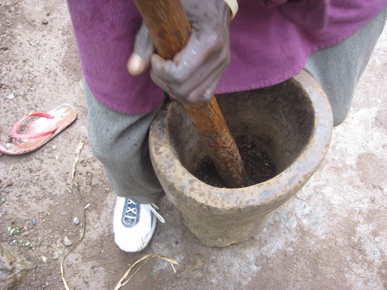 Coffee beans being pounded in a wooden mortar at Marangu