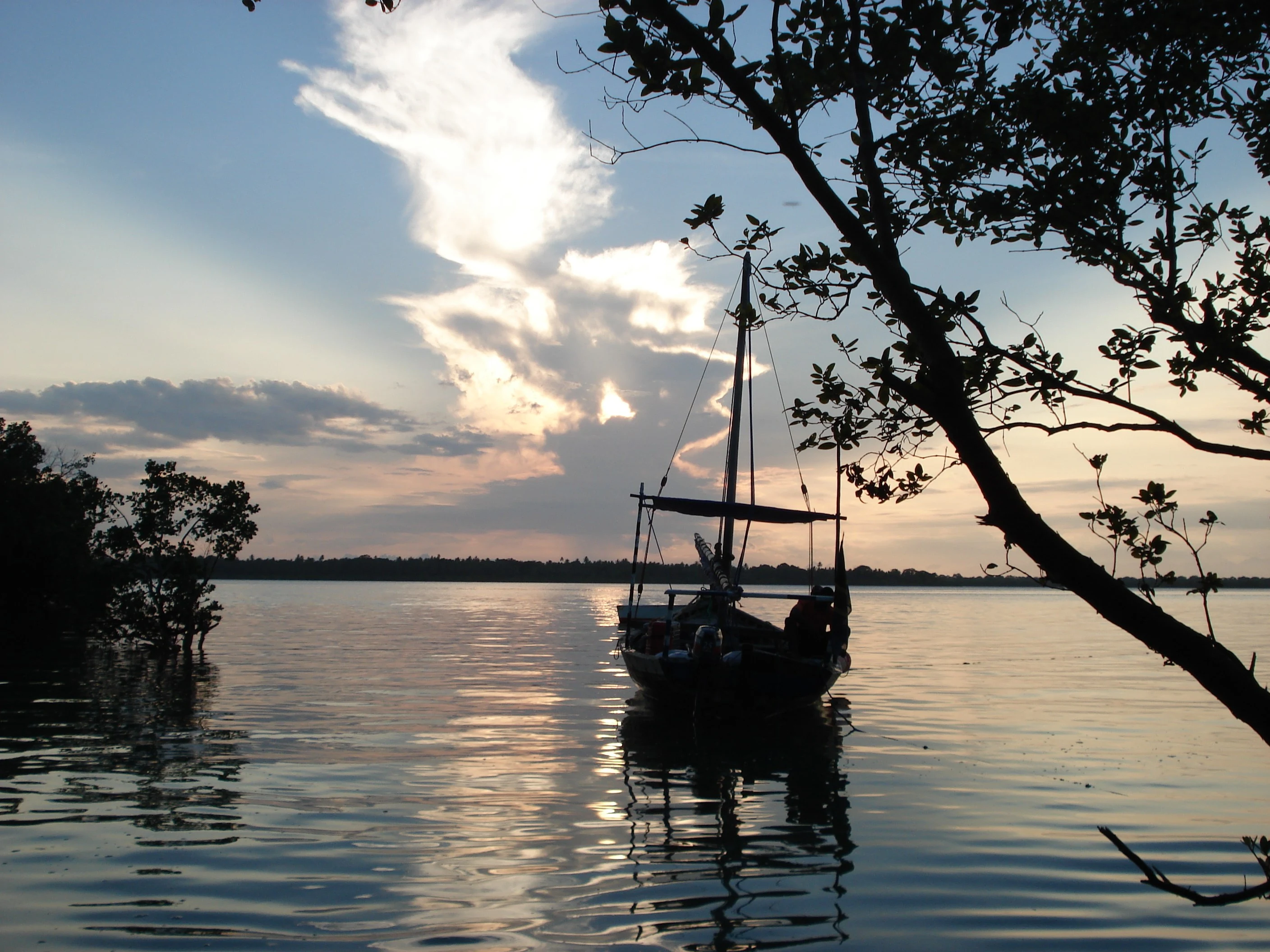 Traditional dhow moored in calm water at sunset off Mafia Island