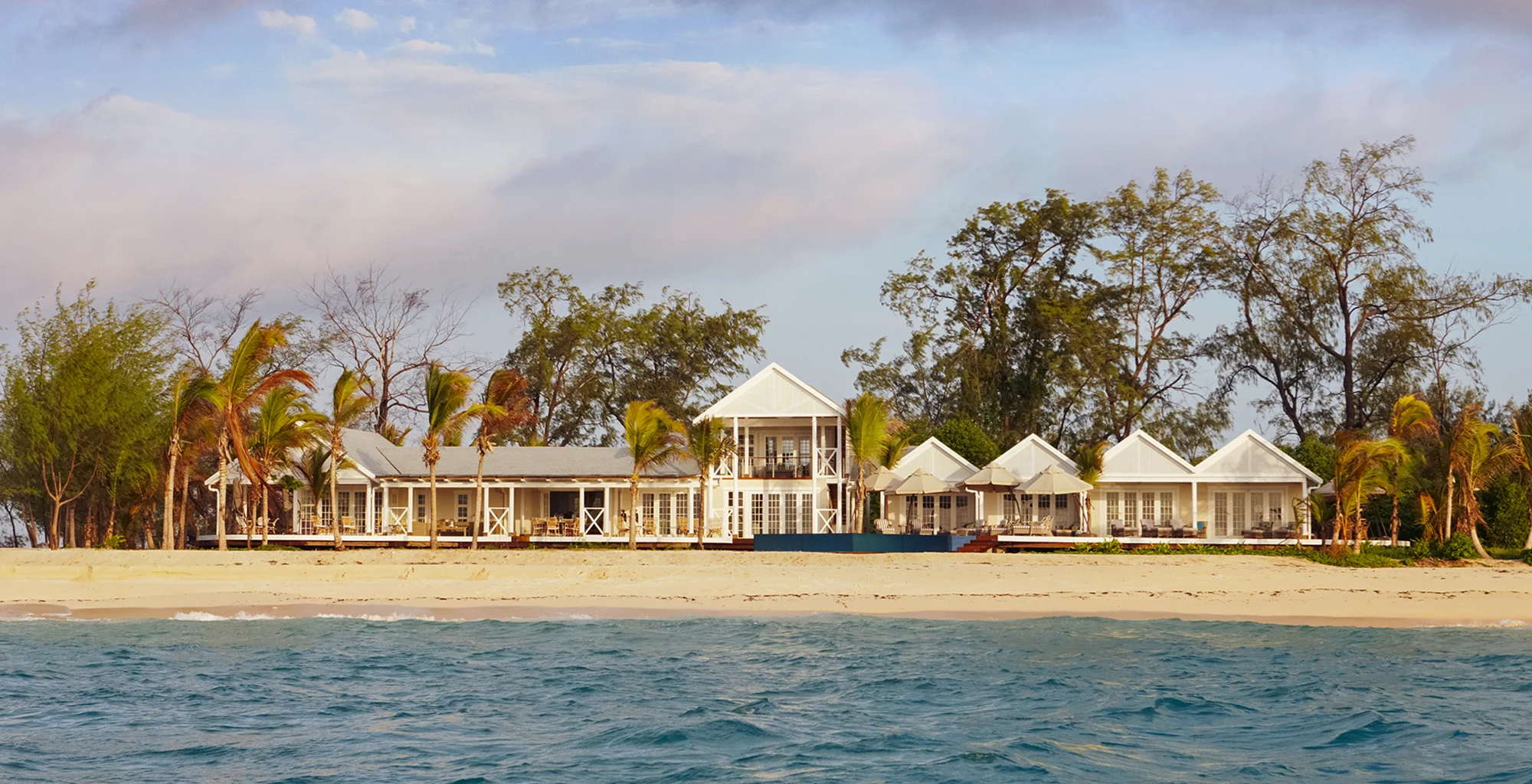 White beach houses among palms on an island shore