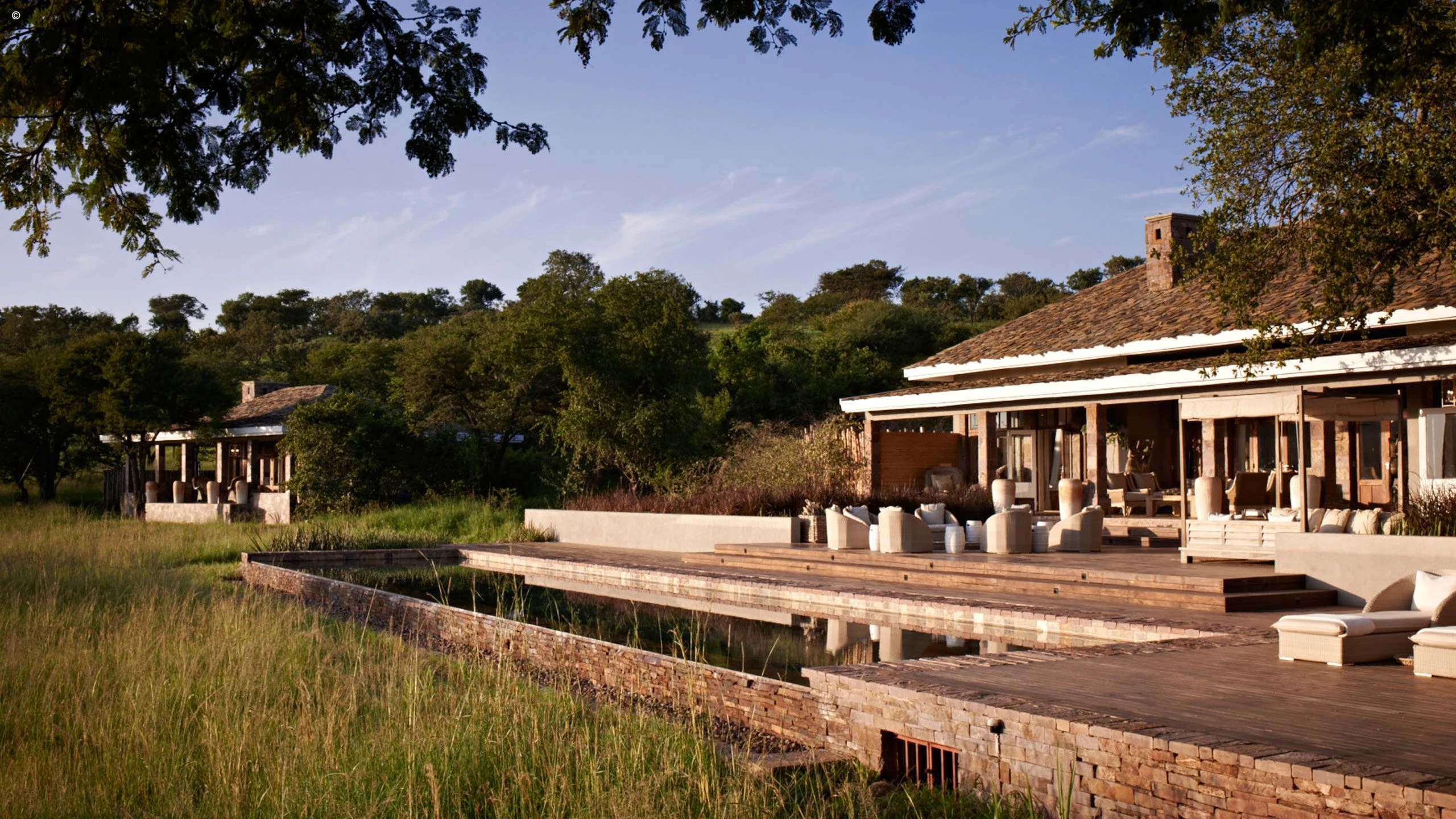 Lodge exterior with broad terraces at Singita Serengeti House