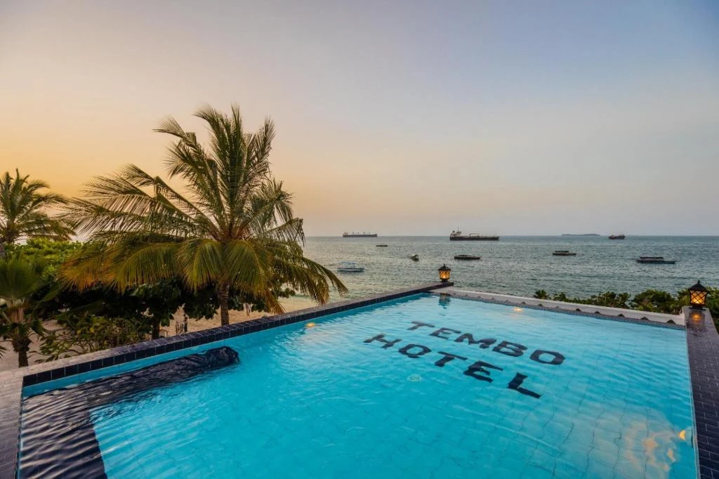 a swimming pool overlooking the ocean at karma hotel at Tembo House Hotel in Zanzibar City