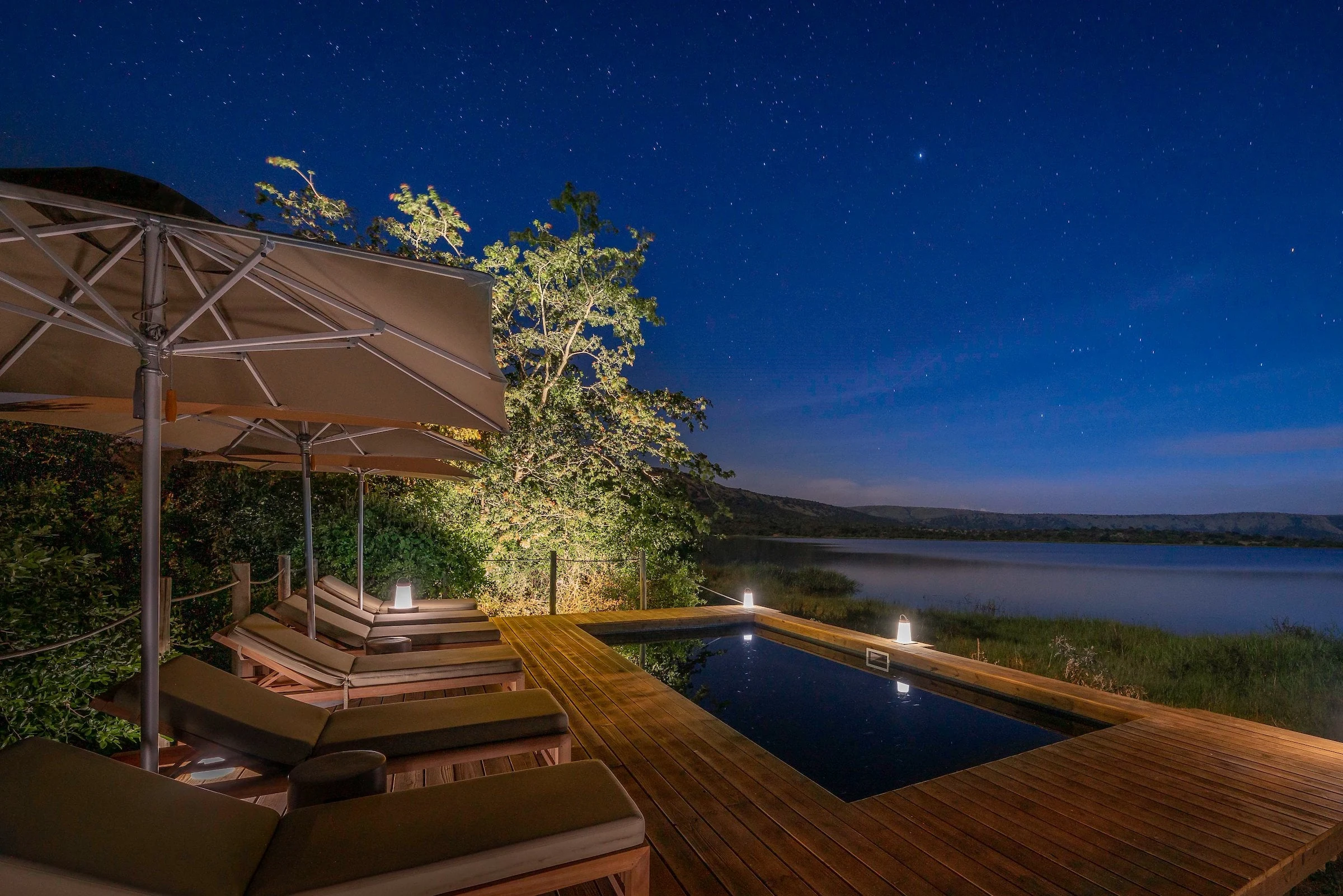 Pool and loungers illuminated at night