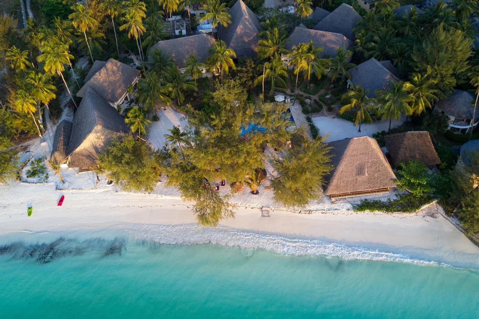 Aerial view of thatched beachfront villas and white sand