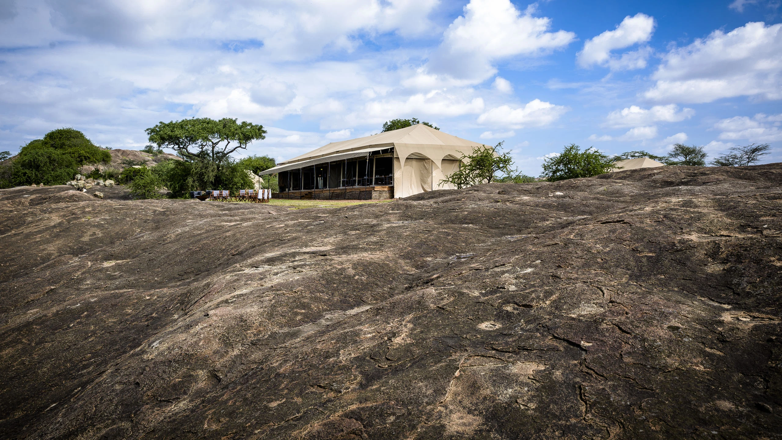 Safari tents on rocky ground in a Serengeti mobile camp