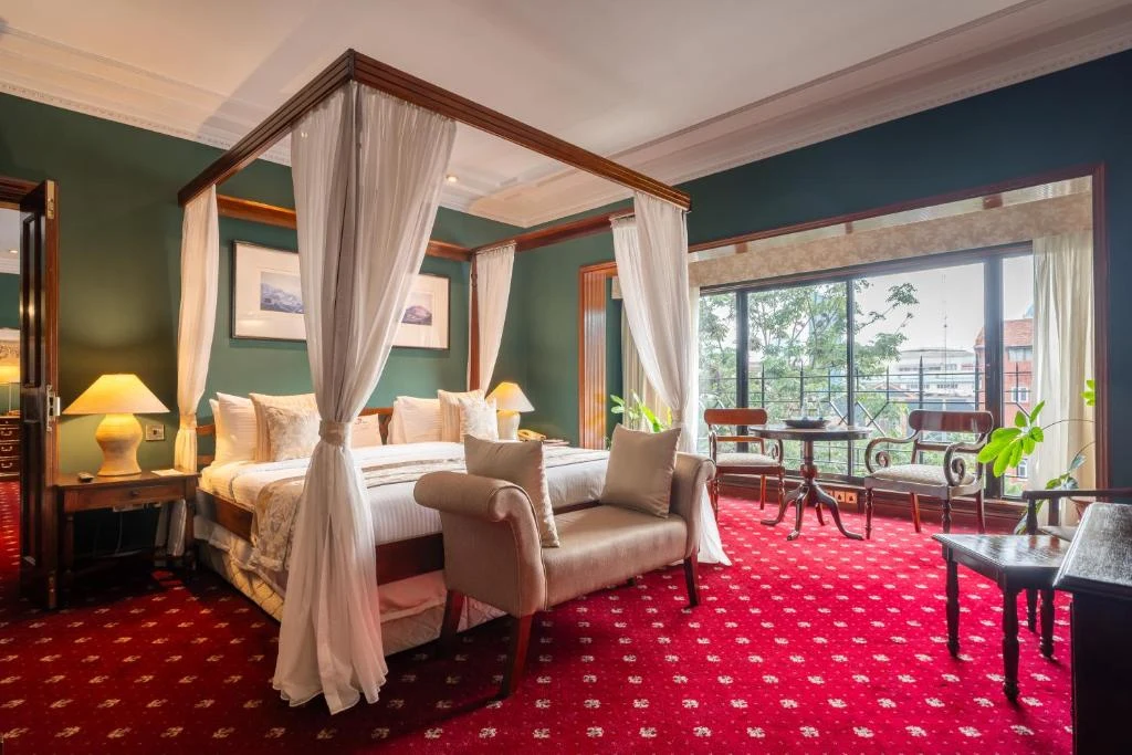 a bedroom with a canopy bed with a chair and a table