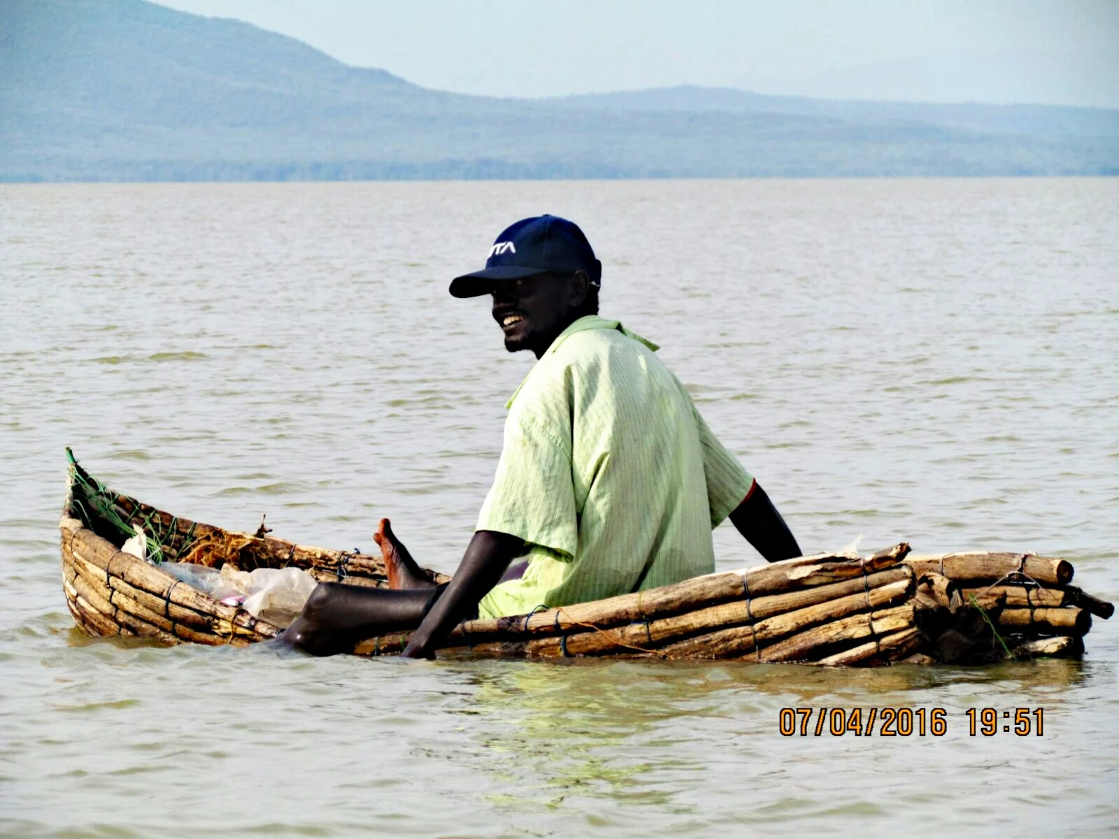 A fisherman paddling a reed raft on Lake Baringo