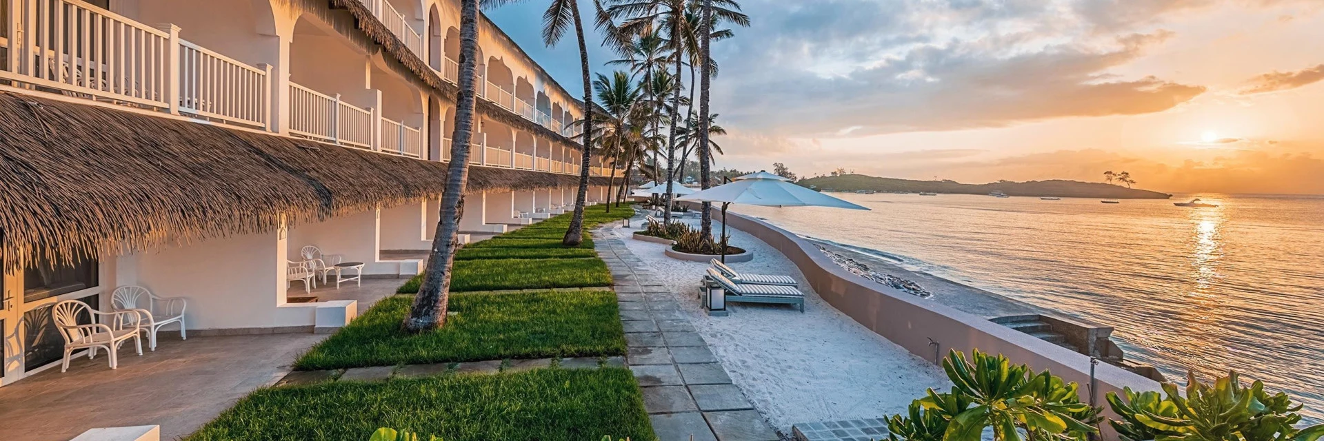 Seafront hotel terraces and lawn on Watamu beach at sunset
