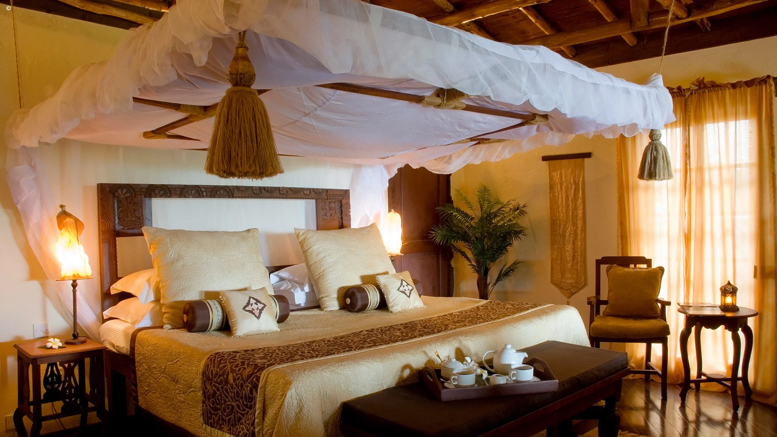 Bedroom with canopy bed and warm lighting at The Palms, Zanzibar