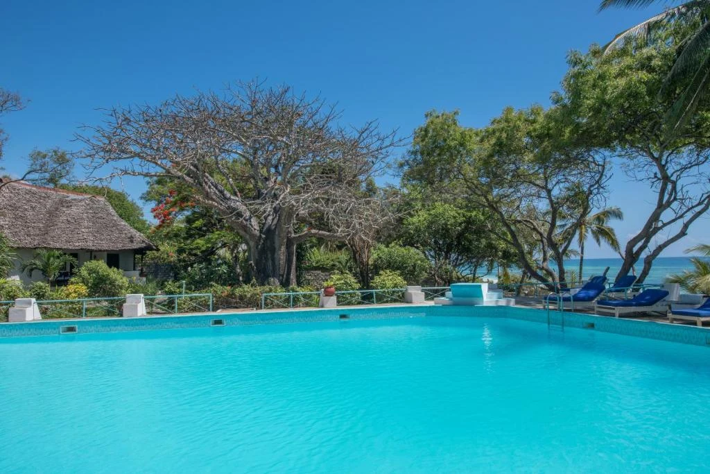a large swimming pool with chairs and trees
