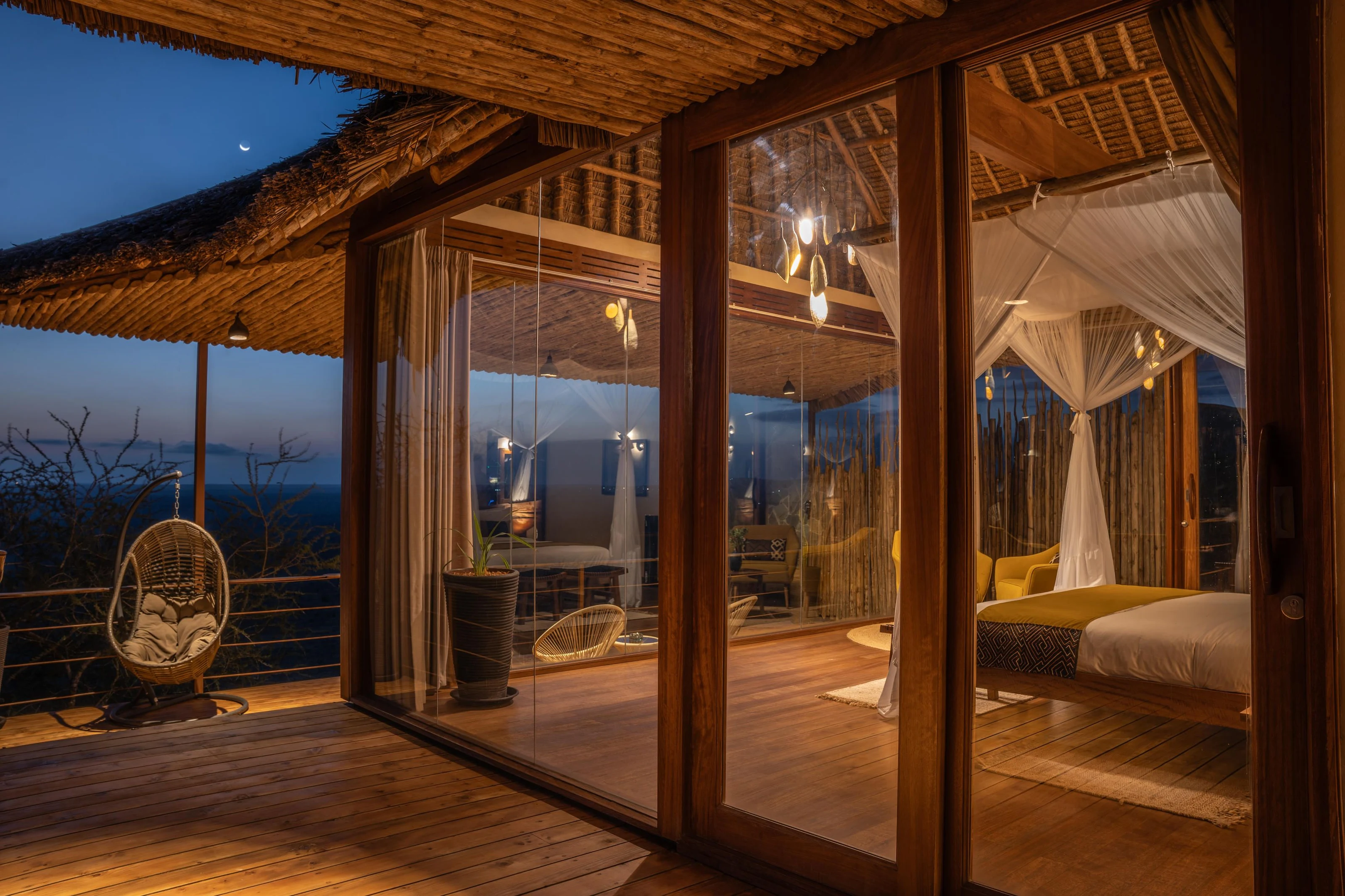 Lantern-lit accommodation and hanging chair at Soroi Lions Bluff Lodge