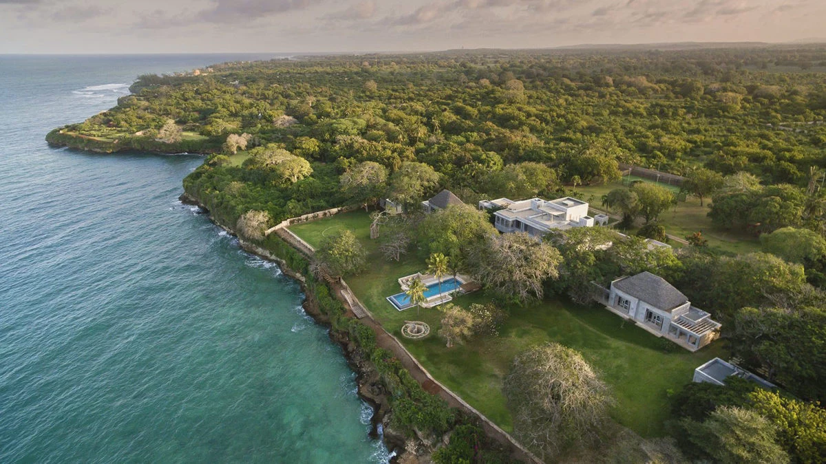 Wooded coastline with houses above the sea on Kenya's coast, seen from the air