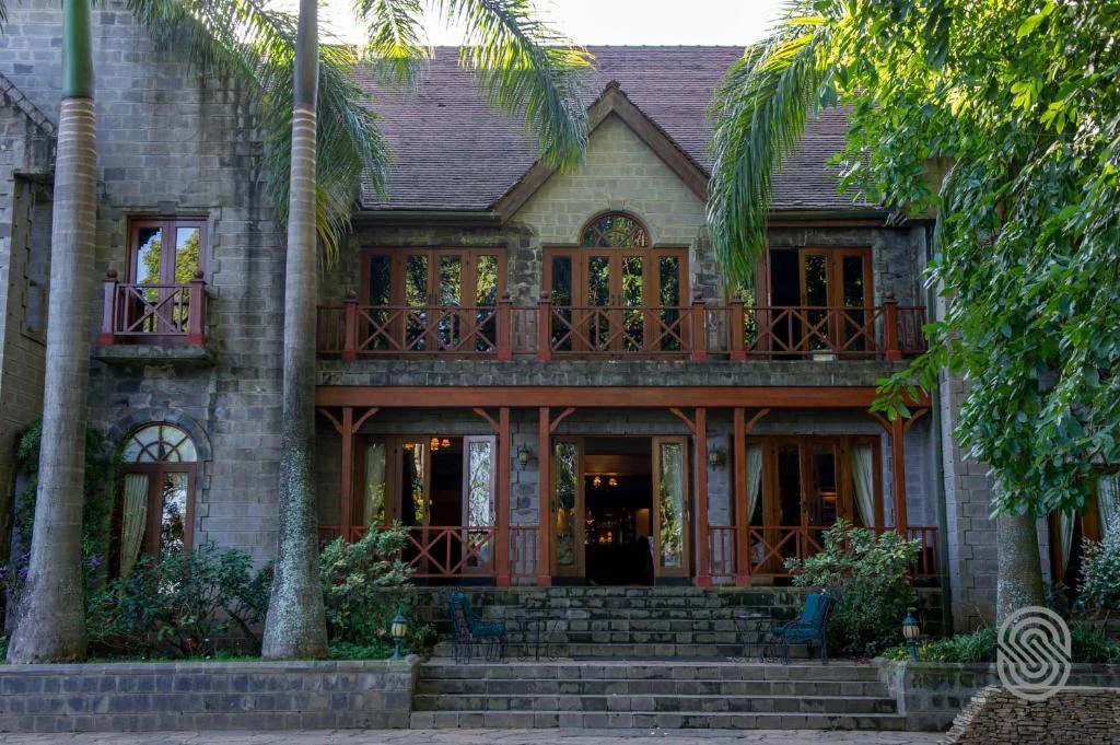 a house with a balcony and palm trees