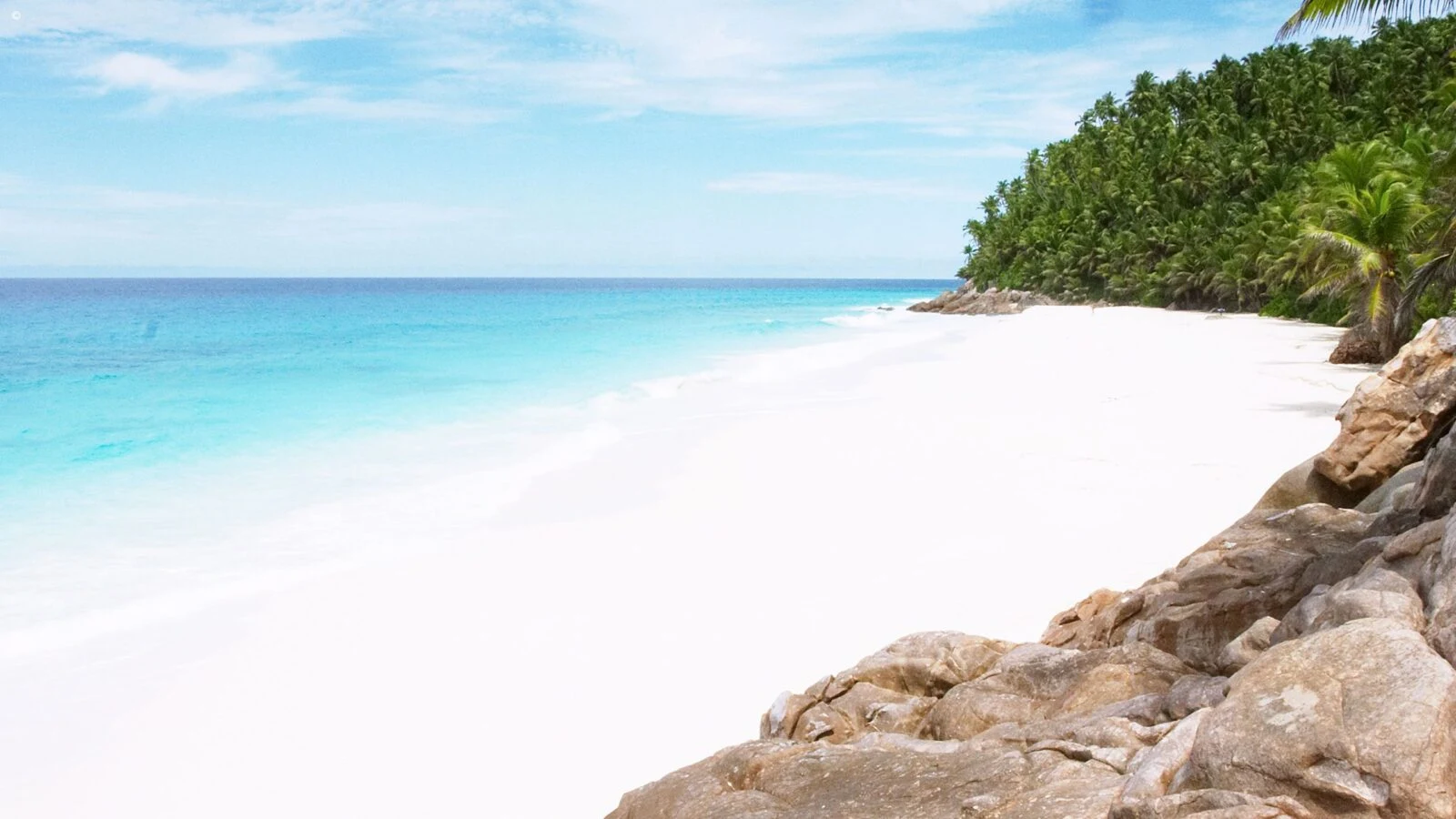 White beach with granite rocks and turquoise water