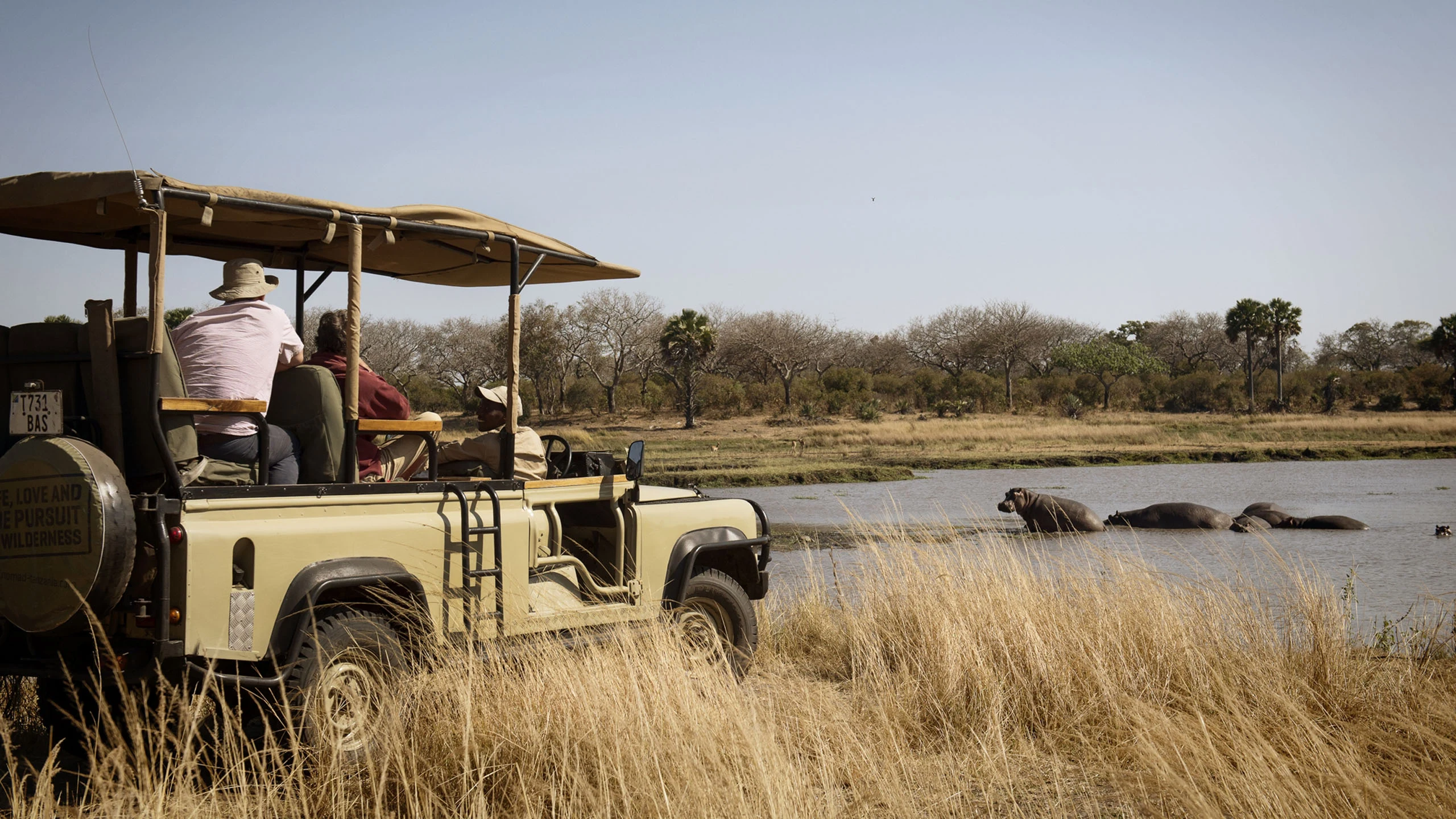 Safari vehicle parked beside a river in Katavi National Park