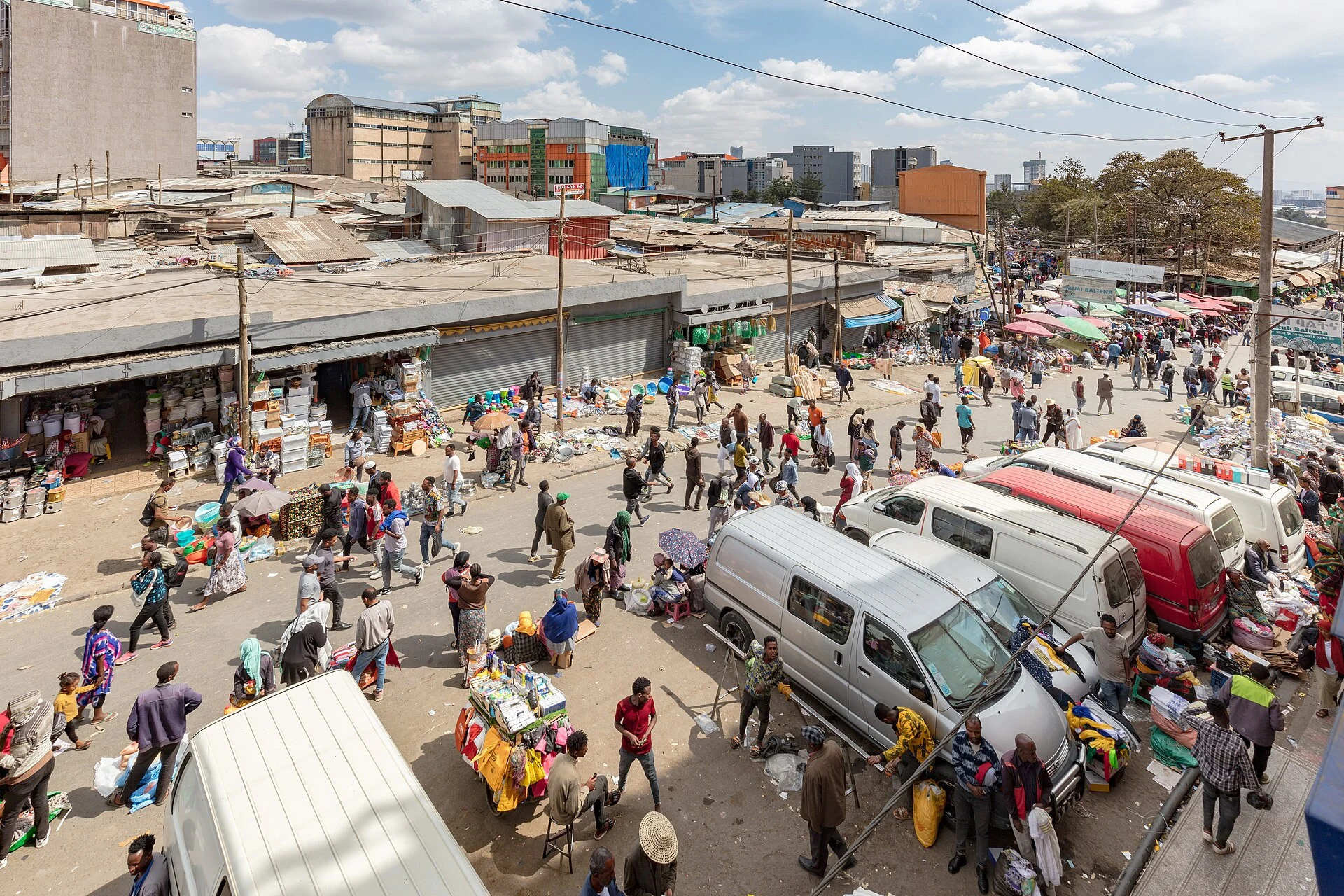 Crowds, minibuses and market stalls fill a street in the Addis Mercato.