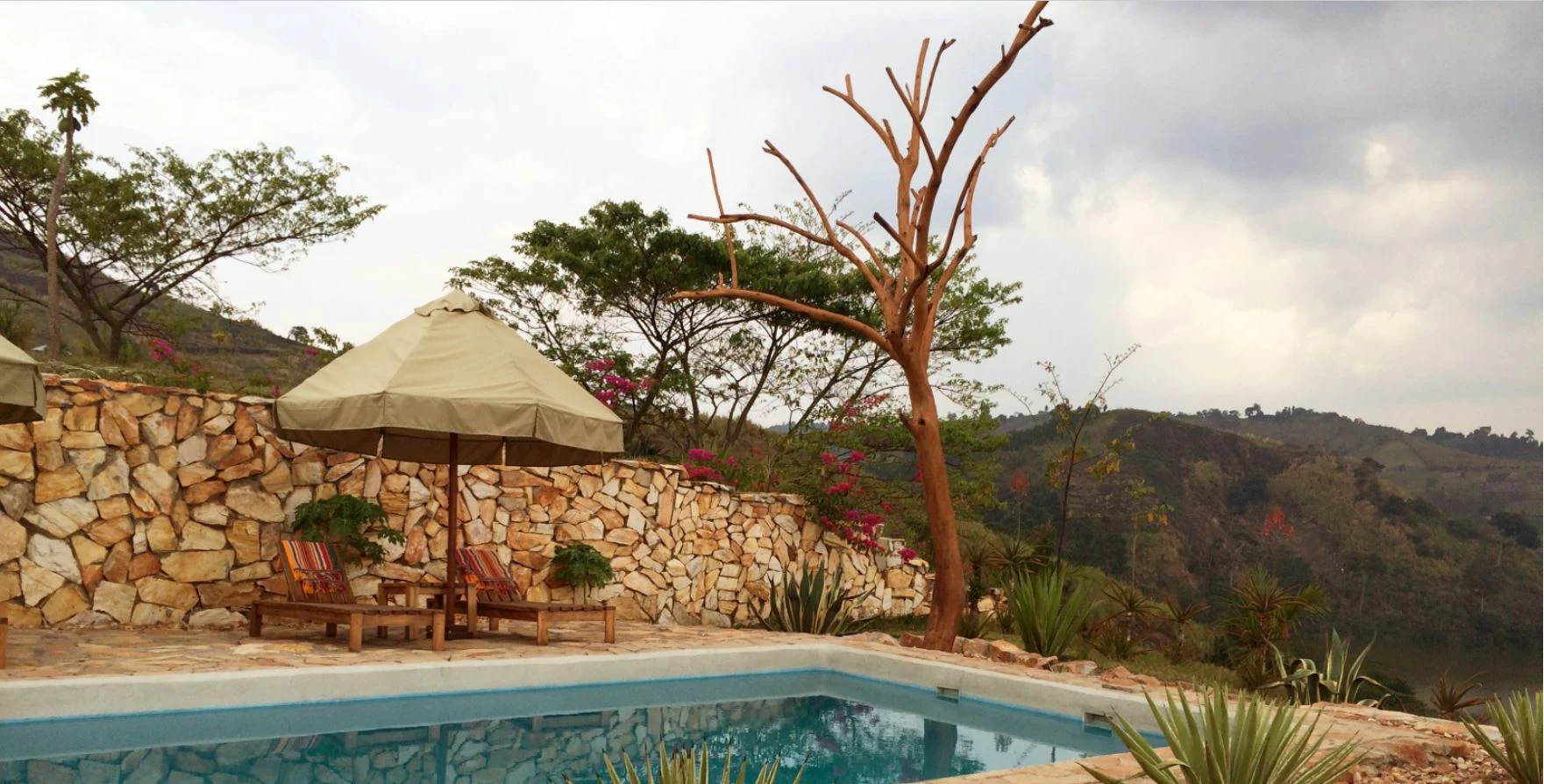 Pool beside stone wall at Papaya Lake Lodge