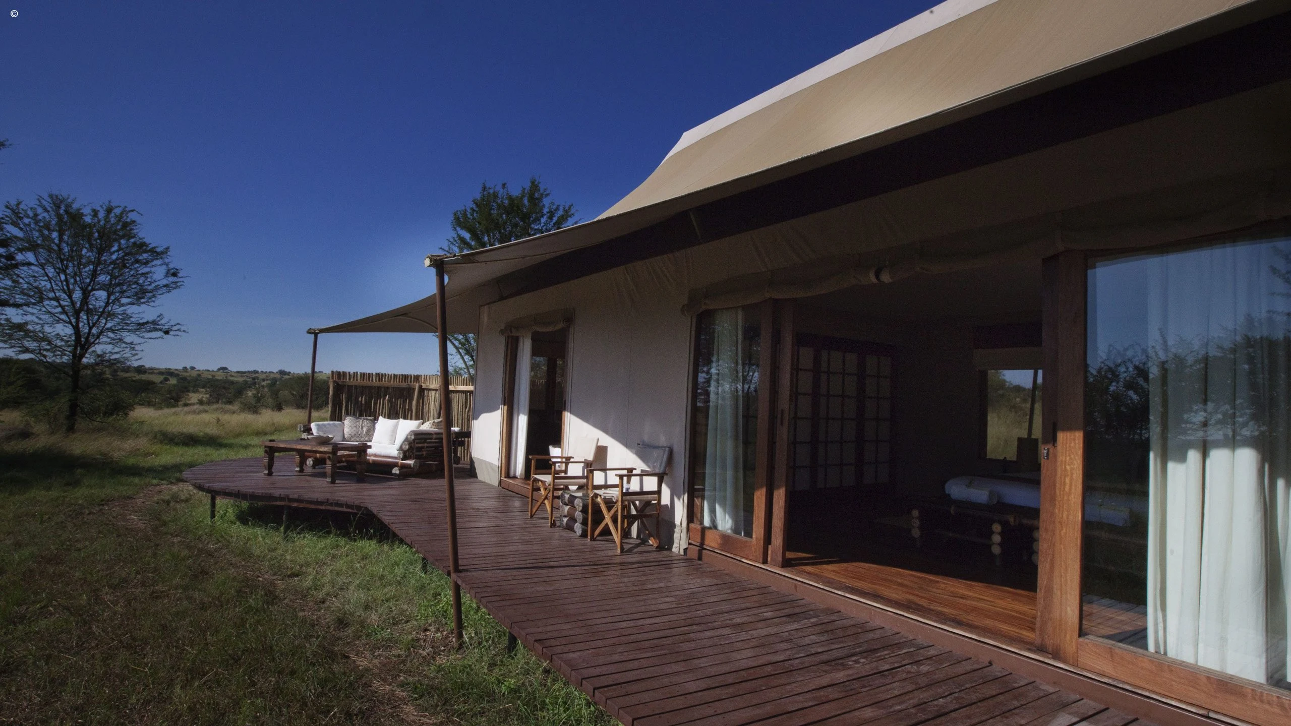 Lodge building and wooden veranda at Sayari Camp