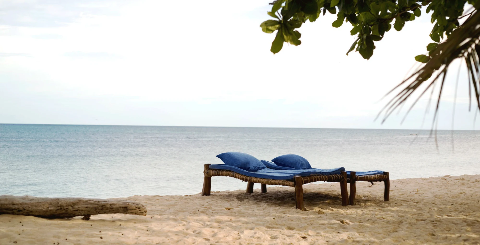 A lounger on an empty beach facing the ocean on Kenya's coast