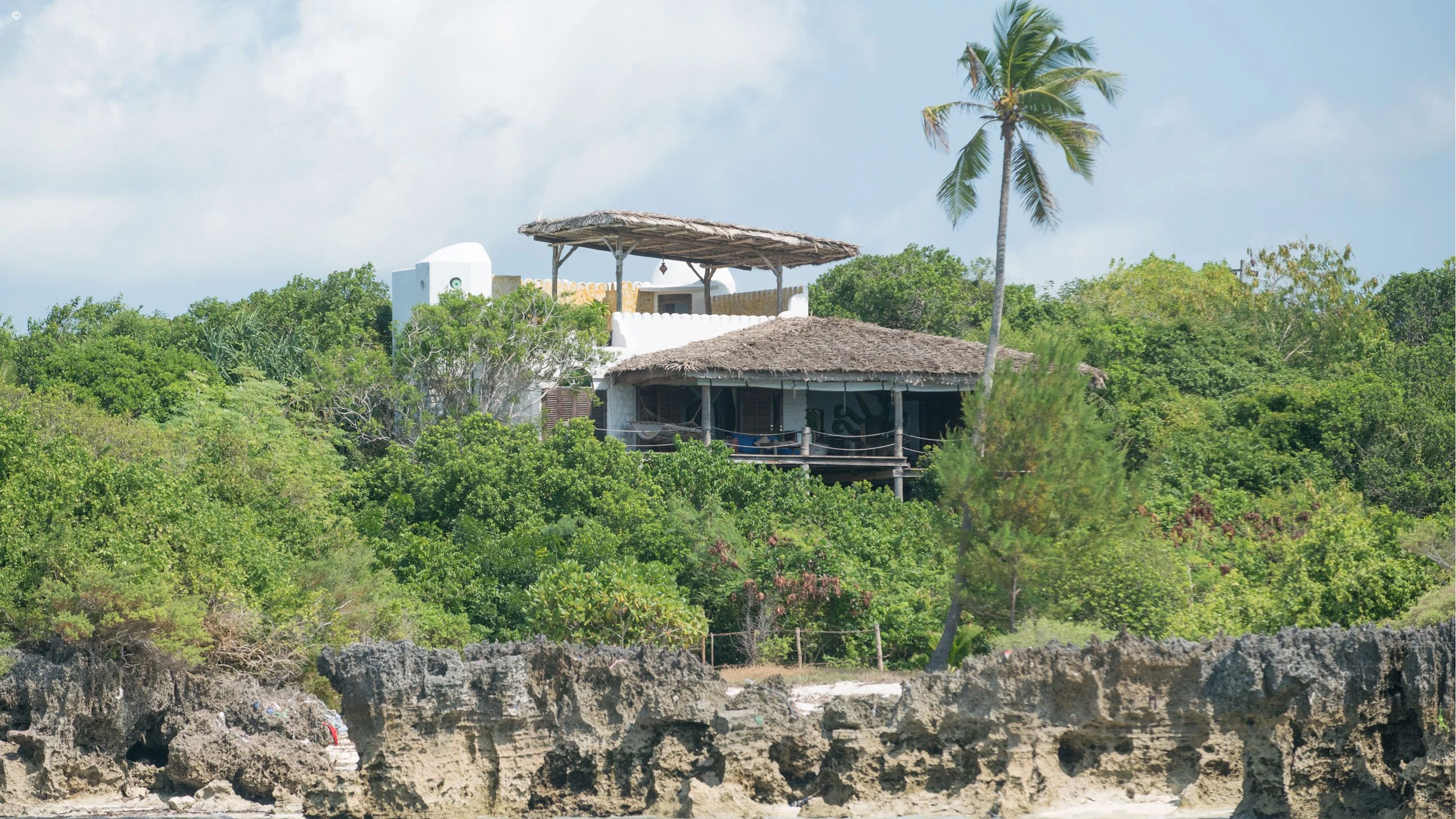 Villa on a rocky coral cliff among dense green trees at Matemwe Retreat