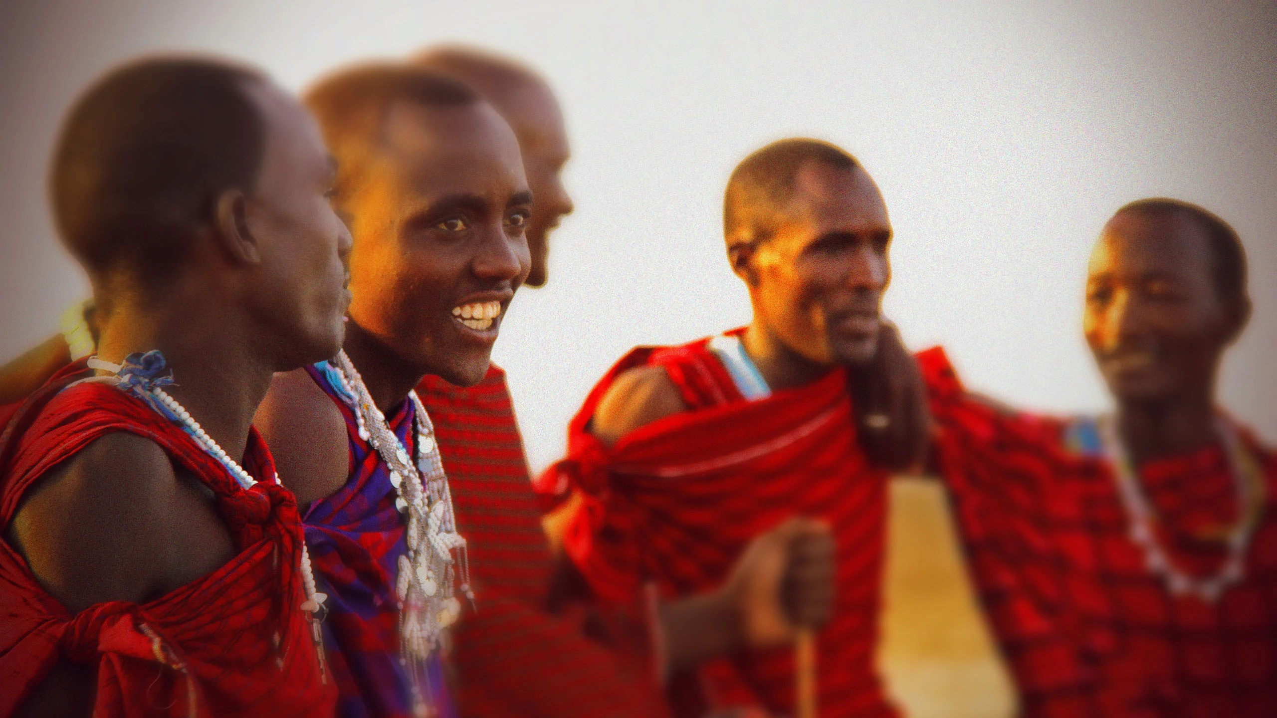 A group of Maasai men in red shukas laughing together