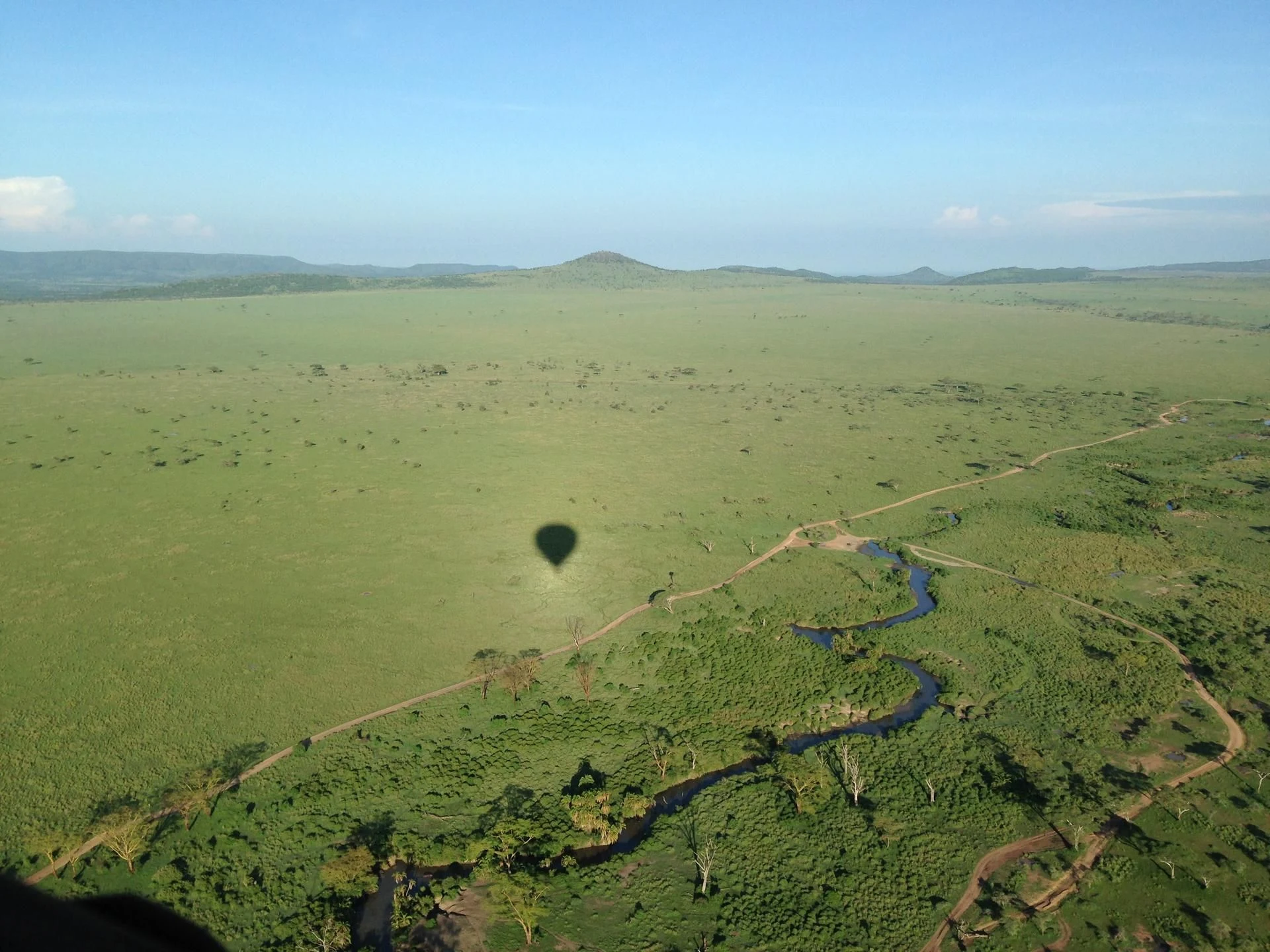 The shadow of a hot-air balloon over green plains near Ndutu