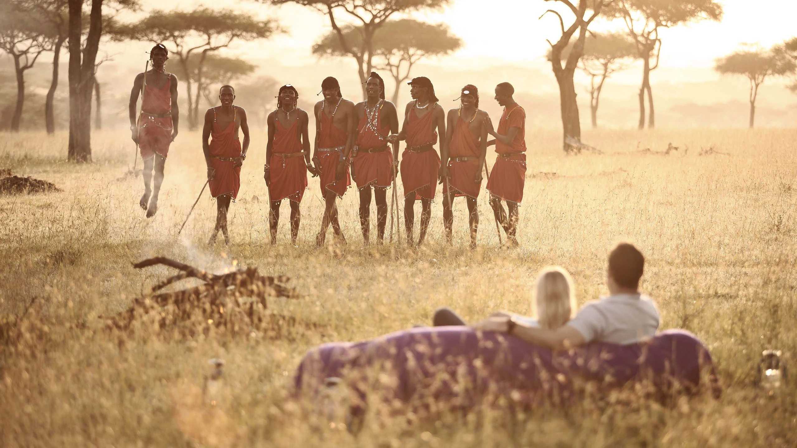 Maasai performers dancing for seated guests at Klein's Camp