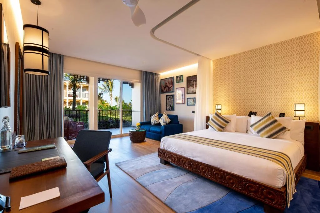 a hotel room with a bed and a desk and a room at The Mora Zanzibar - Luxury All Inclusive in Matemwe
