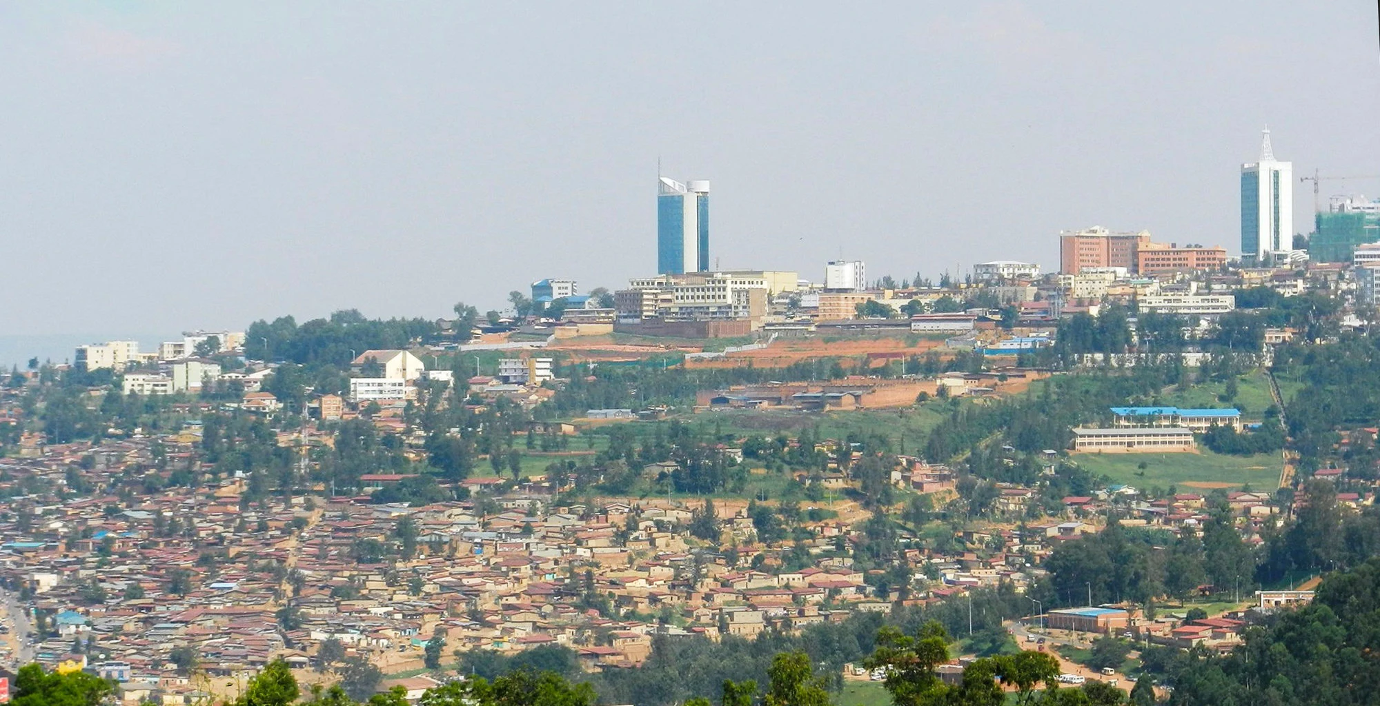 Kigali spread across green hills with tall city-centre buildings on the ridge