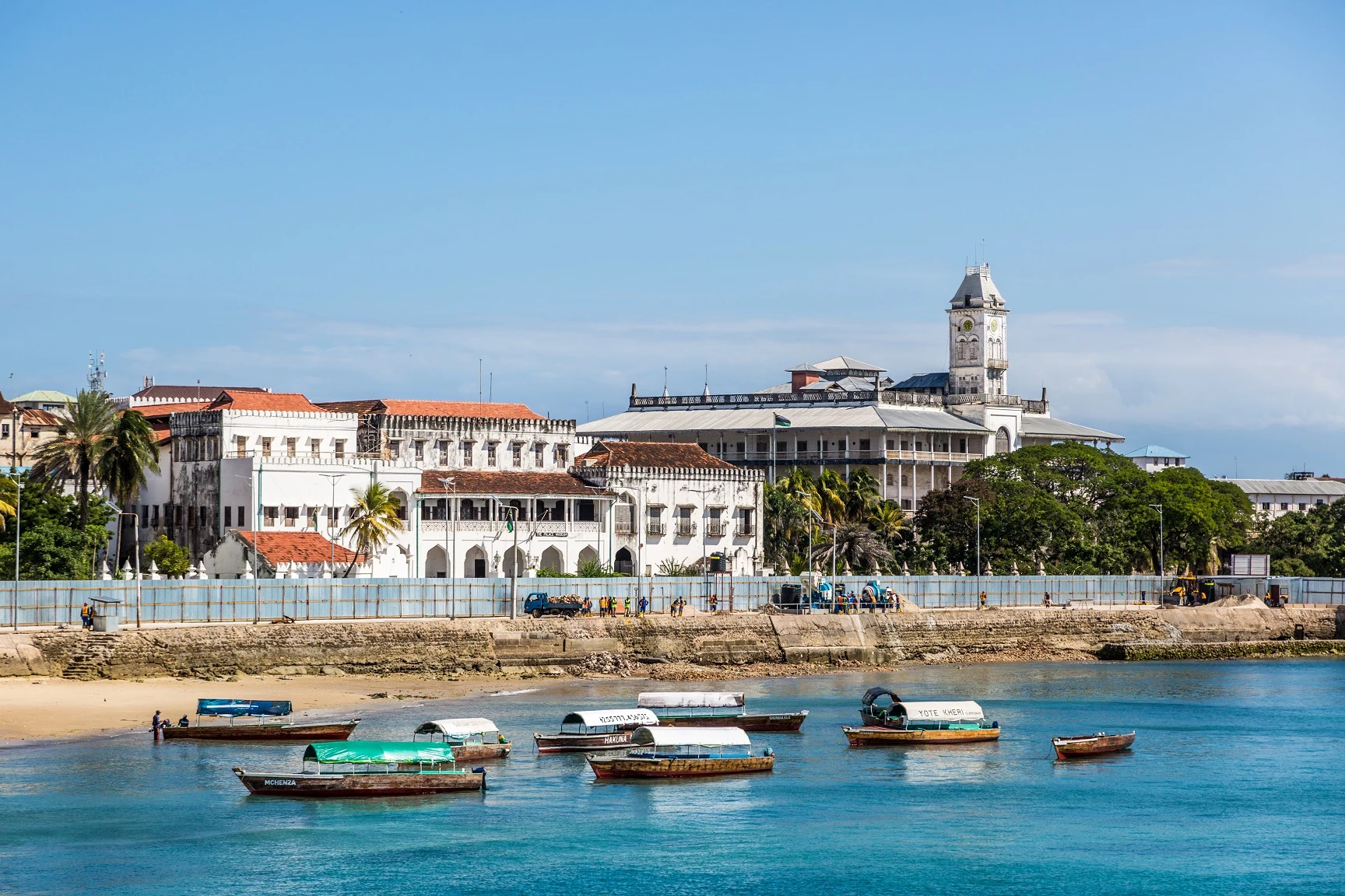 Seafront buildings and the House of Wonders tower above a harbour of small boats