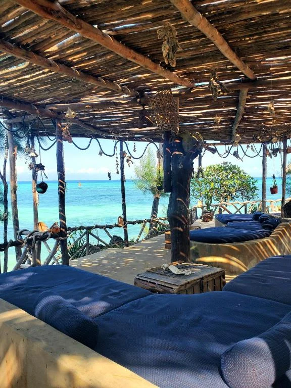 a room with blue beds and the ocean in the background