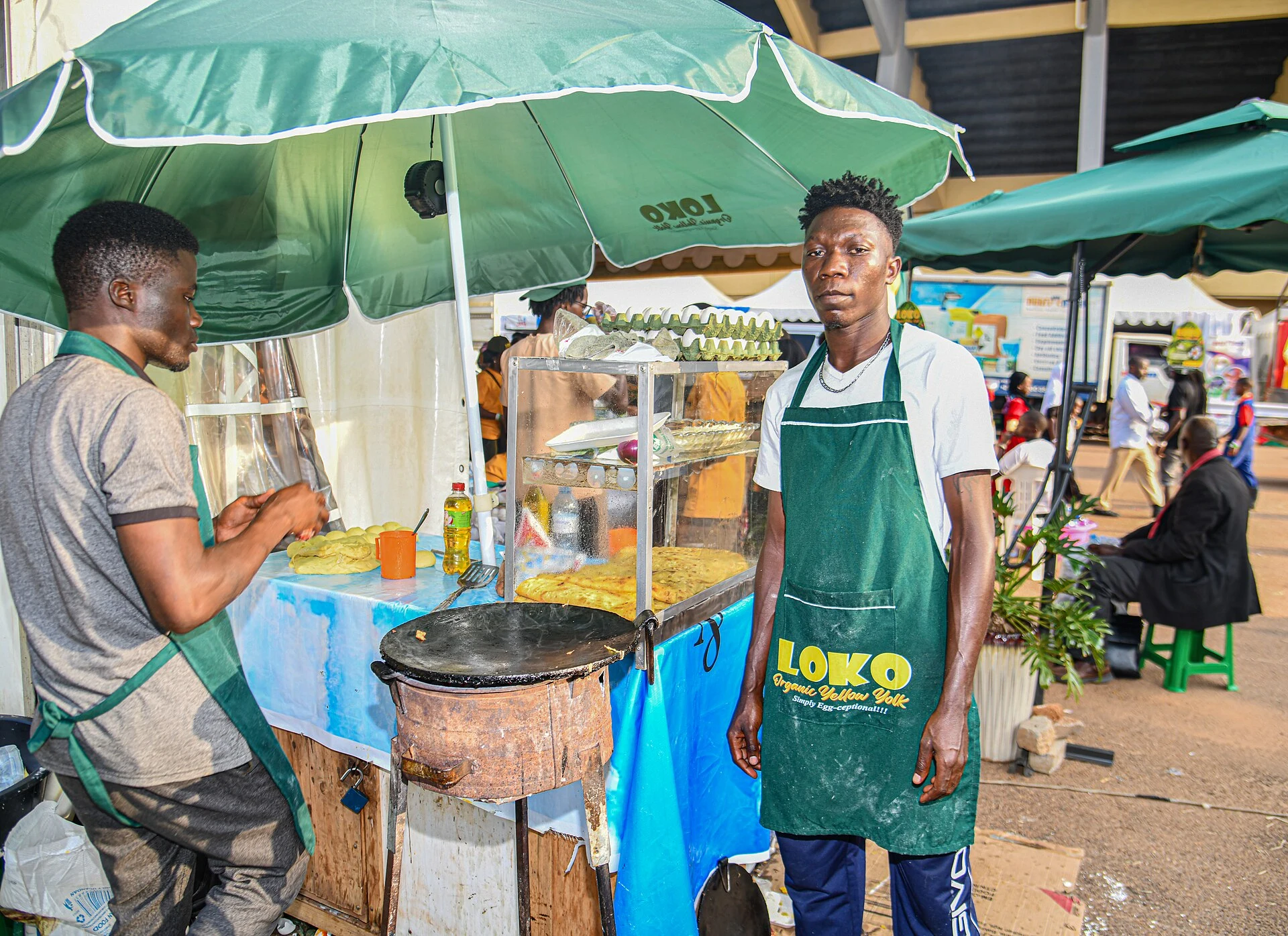 Two cooks at a street stall making rolex, egg rolled in chapati