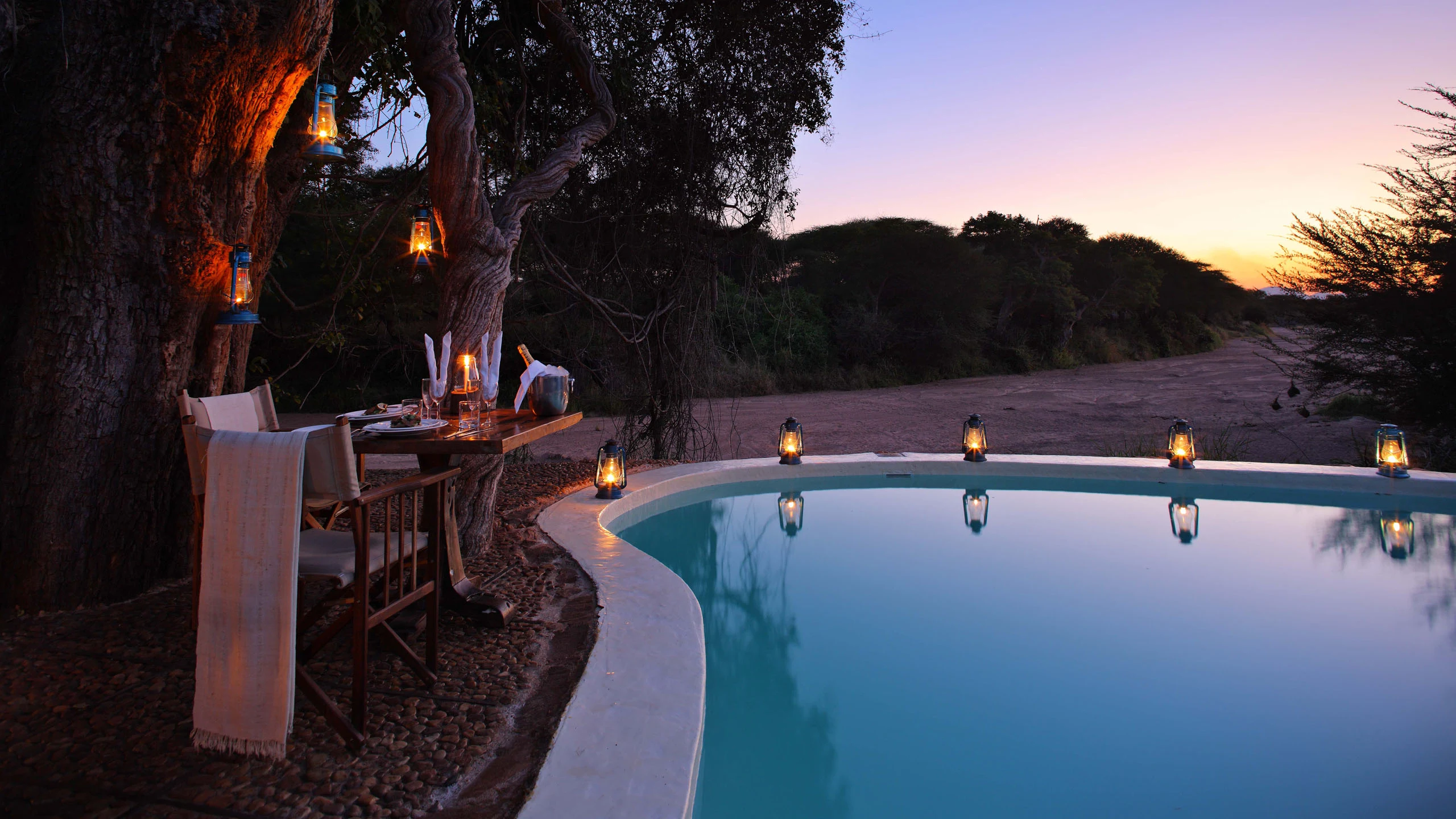 Pool illuminated at dusk at Jongomero Camp