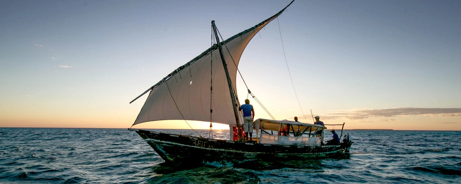 A dhow under sail at sunset on the open sea