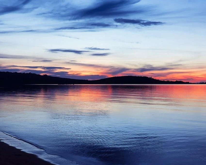 Sunset colours over Lake Victoria with dark hills on the far shore
