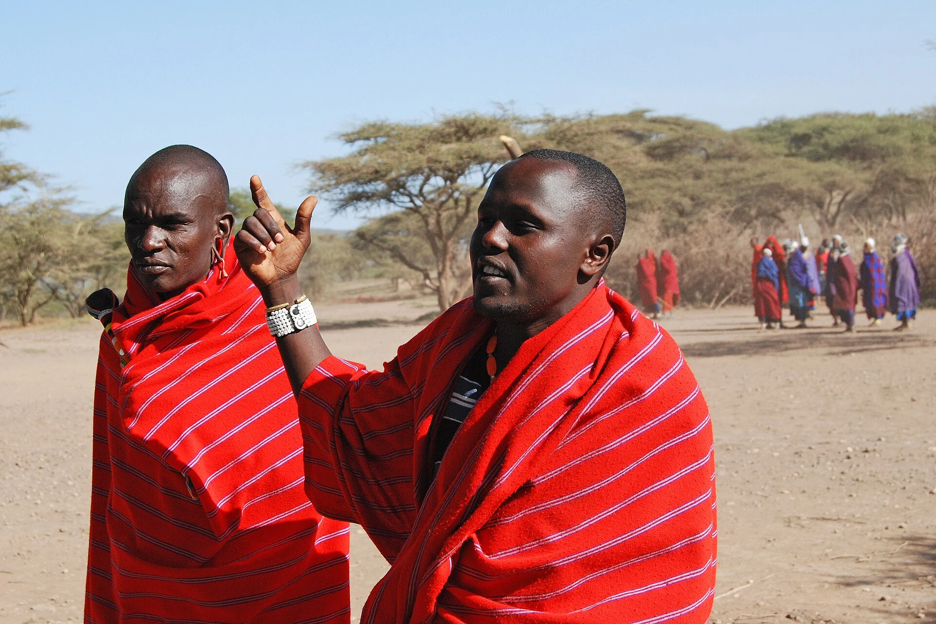 Maasai villagers in red cloth greeting visitors at their village