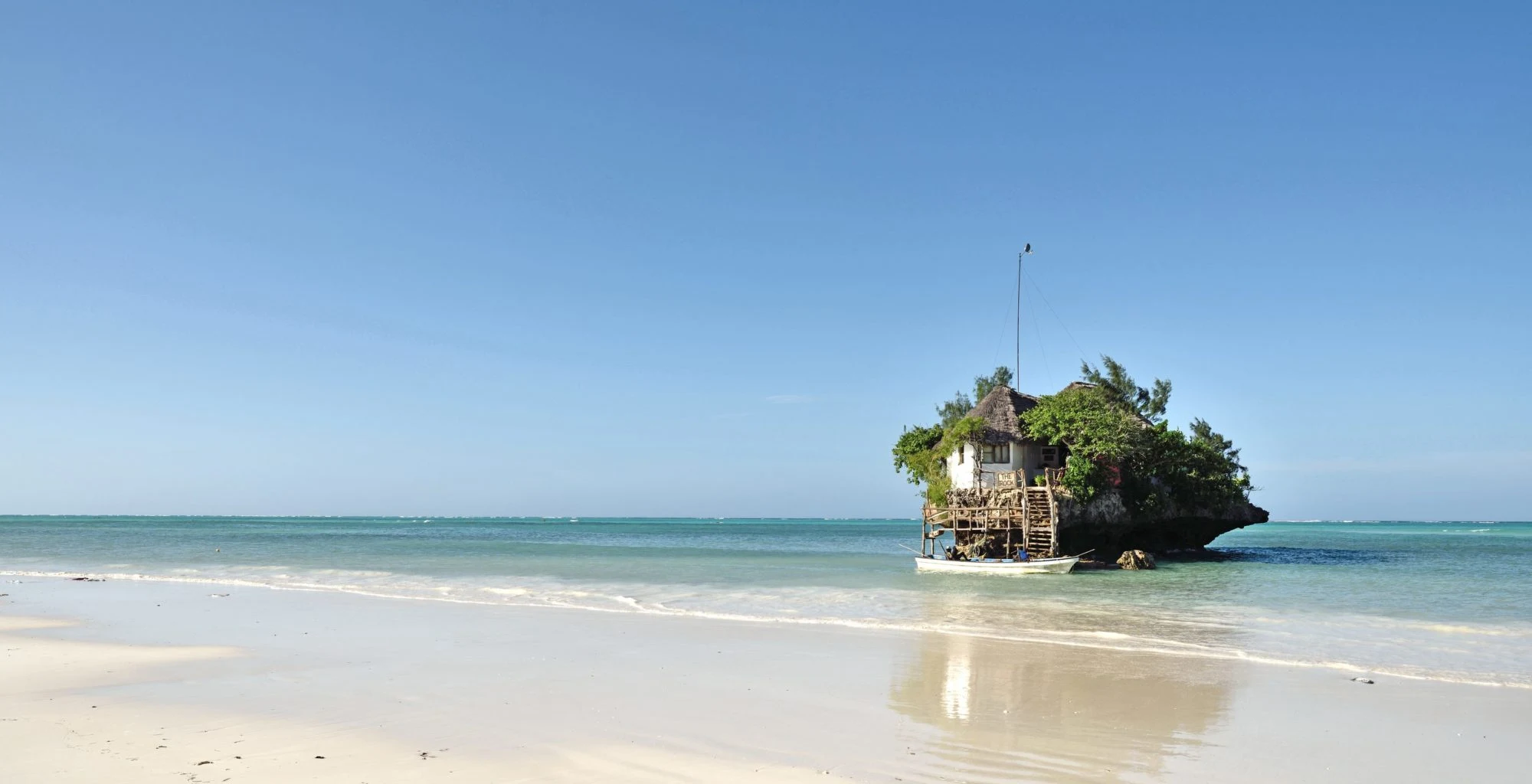 The Rock restaurant on its coral outcrop off a white beach at high tide