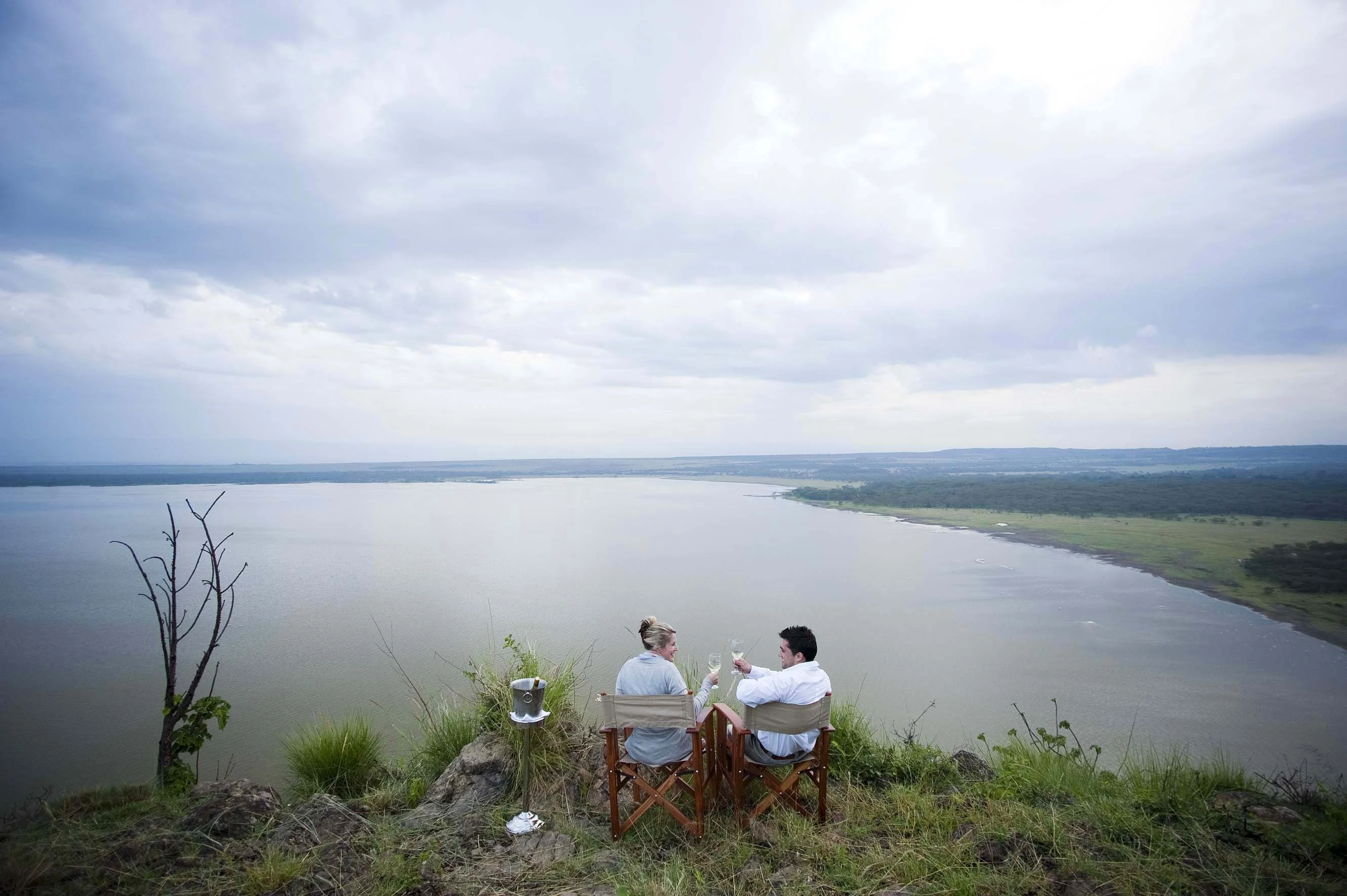 Two guests seated on a ridge above Lake Elementaita
