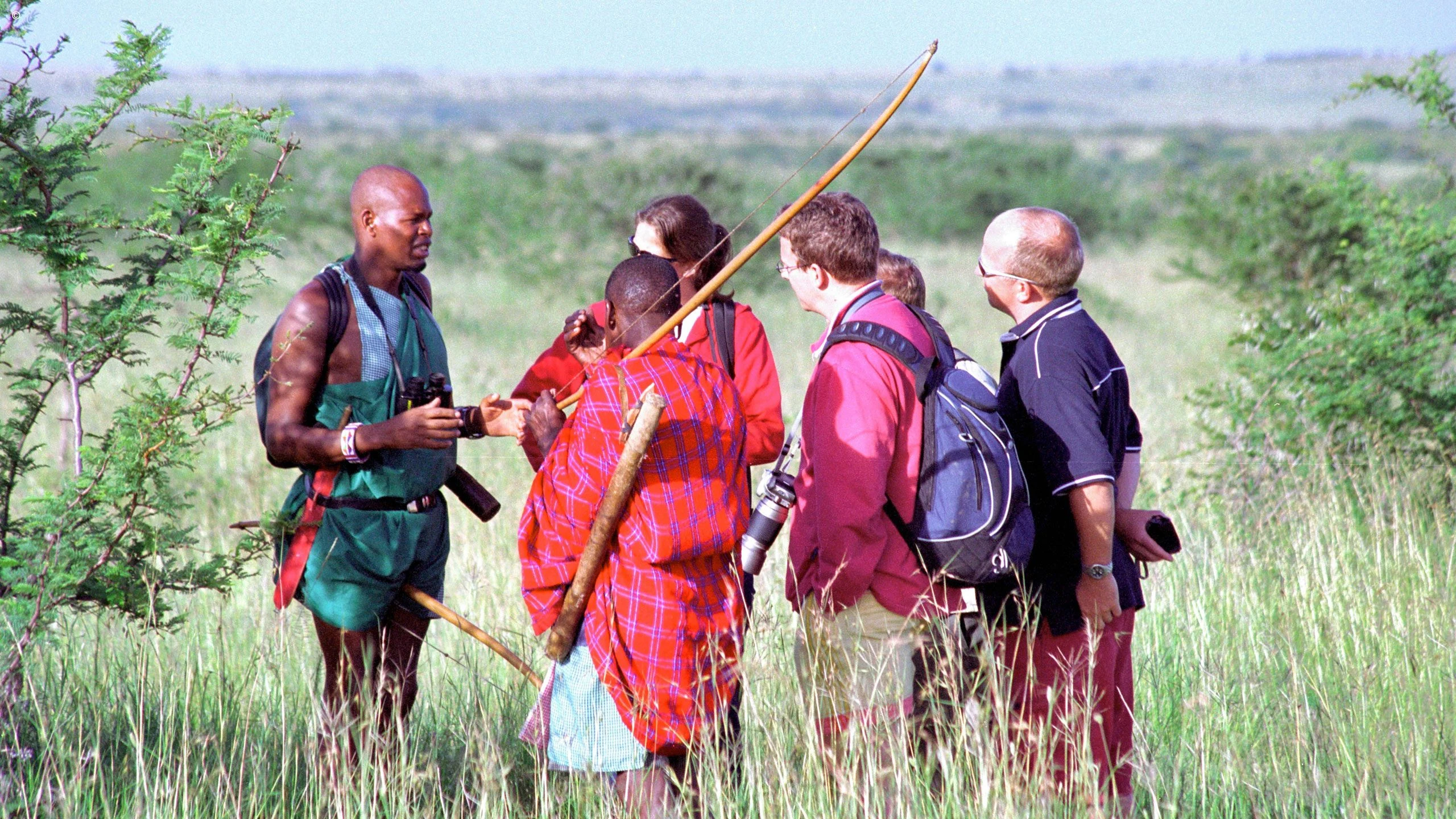 Maasai hosts talking with walking guests in Naboisho