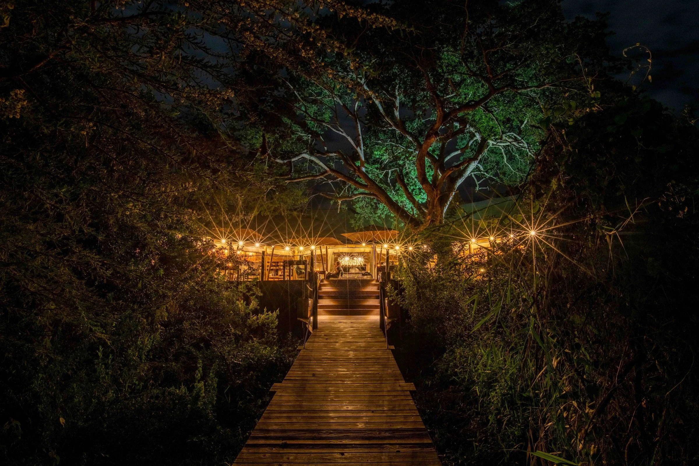 Lantern lined bridge toward a lodge
