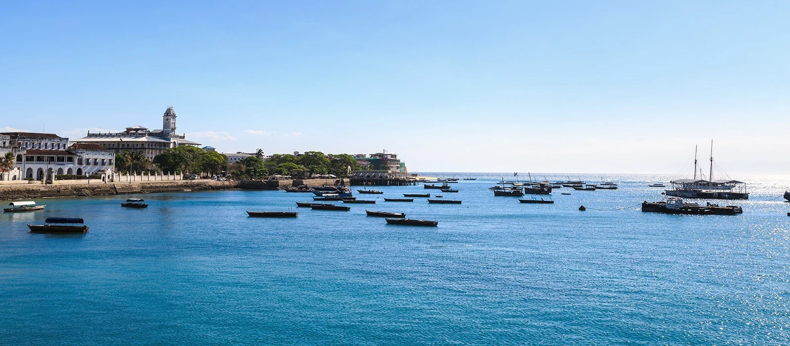 Small boats moored in the harbour in front of Stone Town's seafront