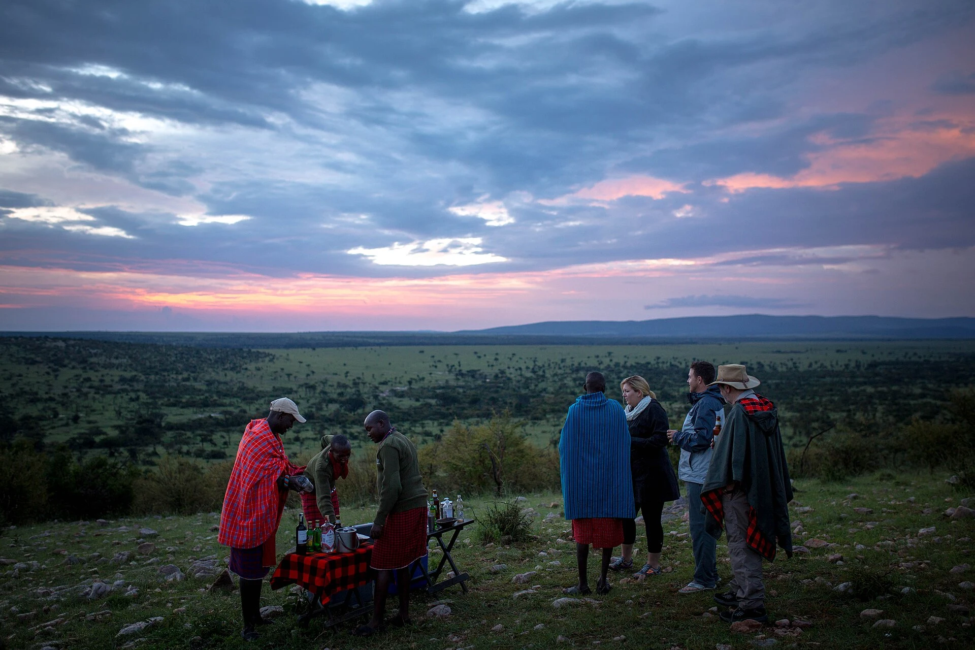 Guests with Maasai guides at dusk in Ol Kinyei